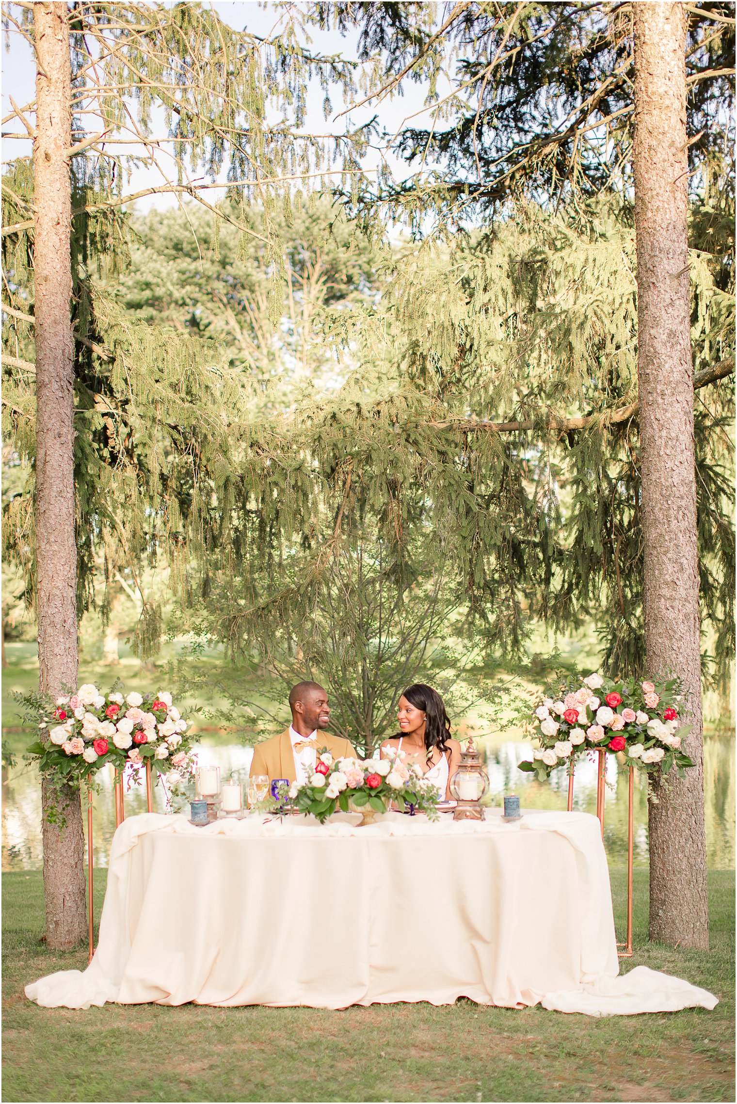 newlyweds sit at sweetheart table during fall wedding at Windows on the Water at Frogbridge