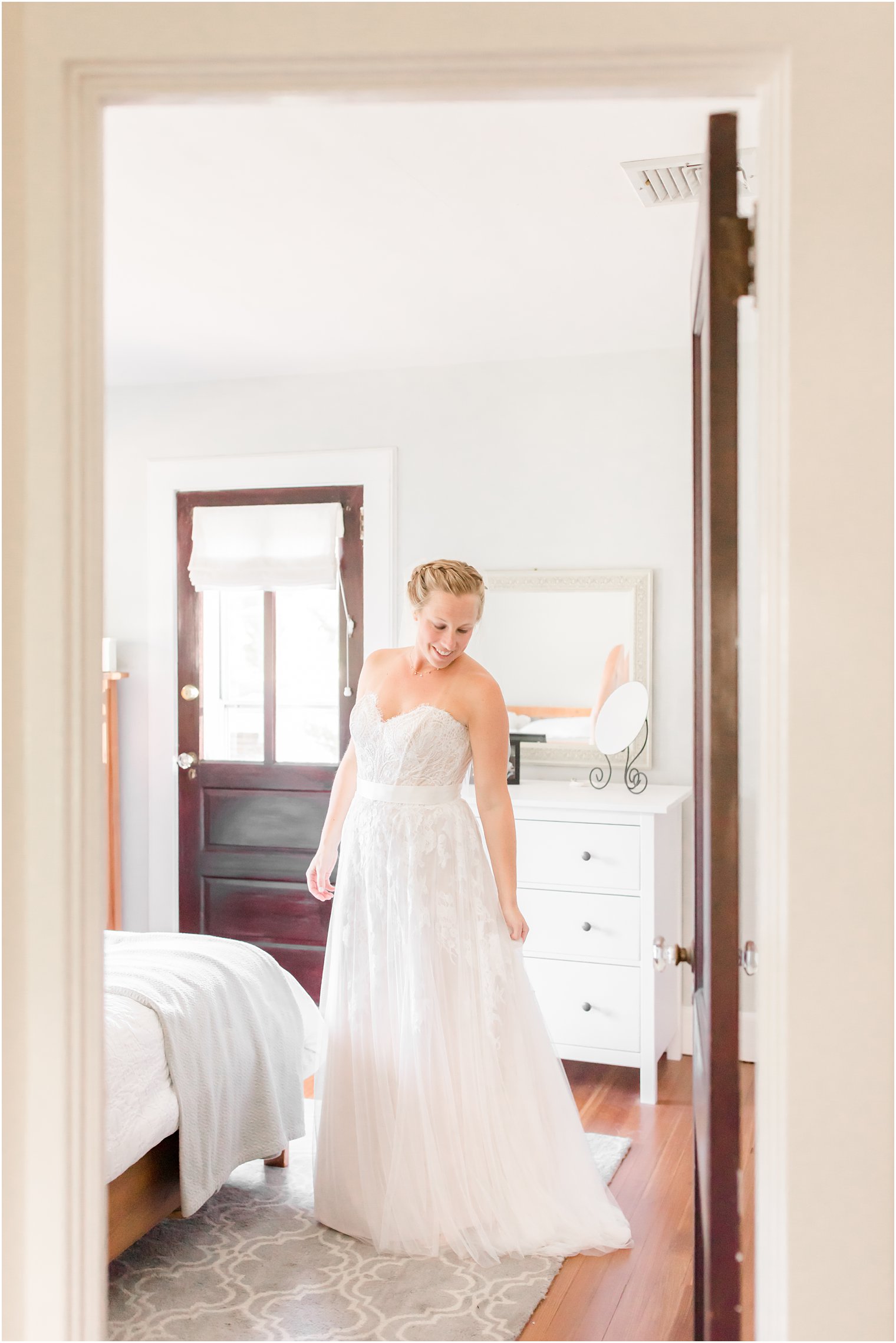 bride looks over shoulder at wedding gown before NJ wedding