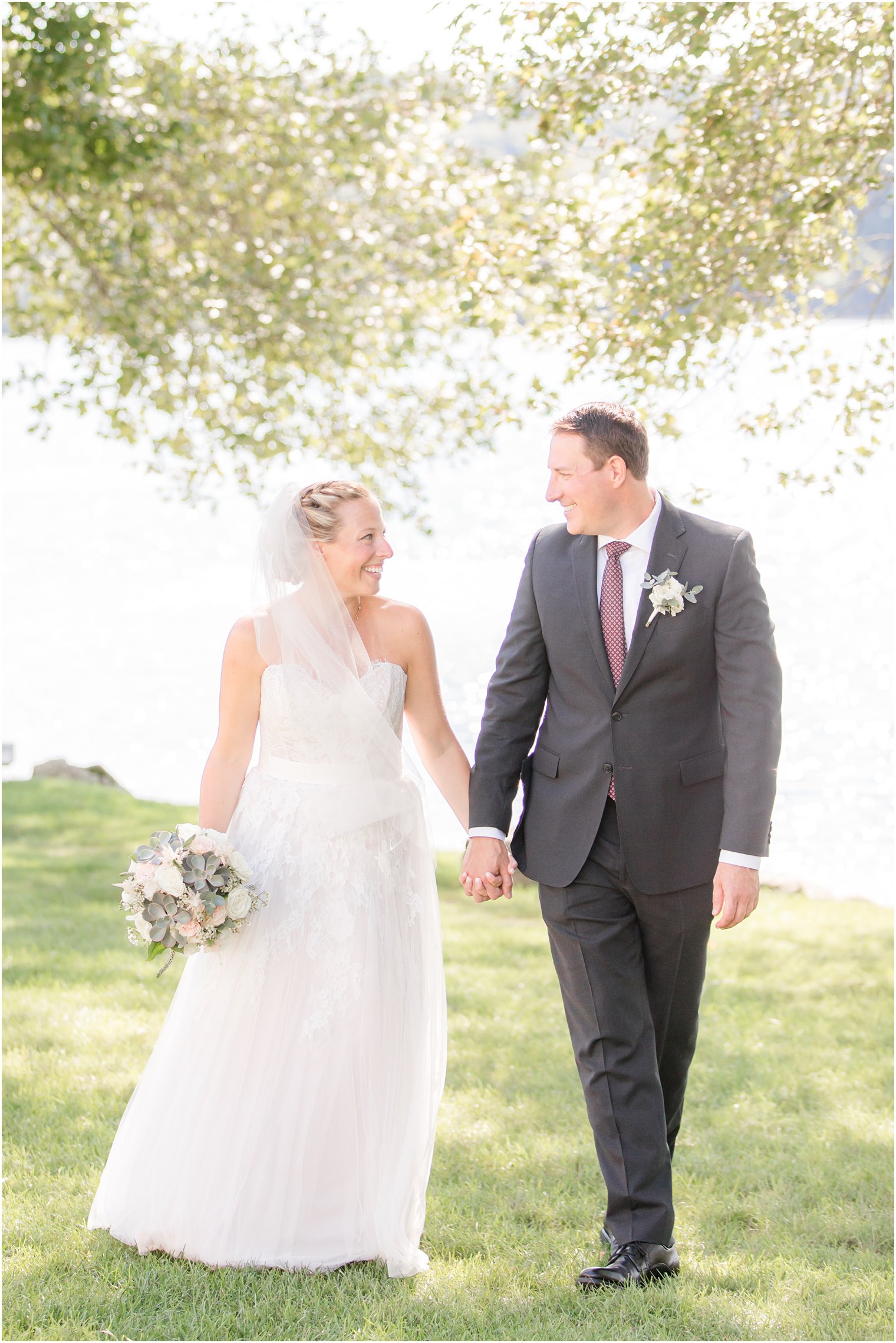 bride and groom walk along lake at Indian Trail Club