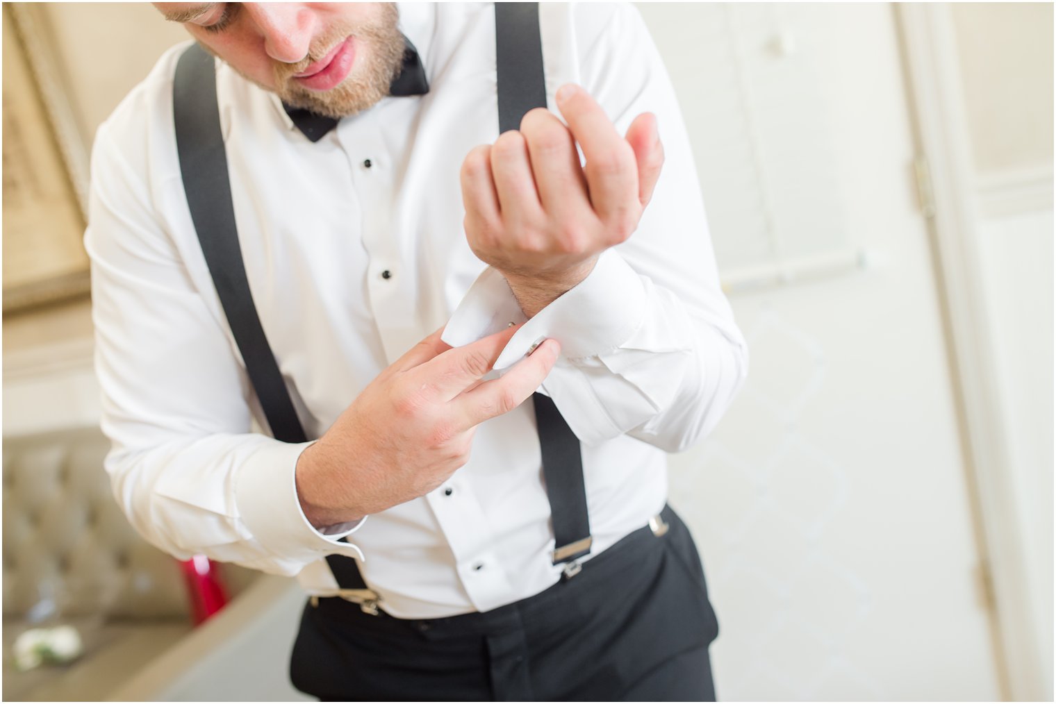 groom adjusts cufflinks before NJ wedding