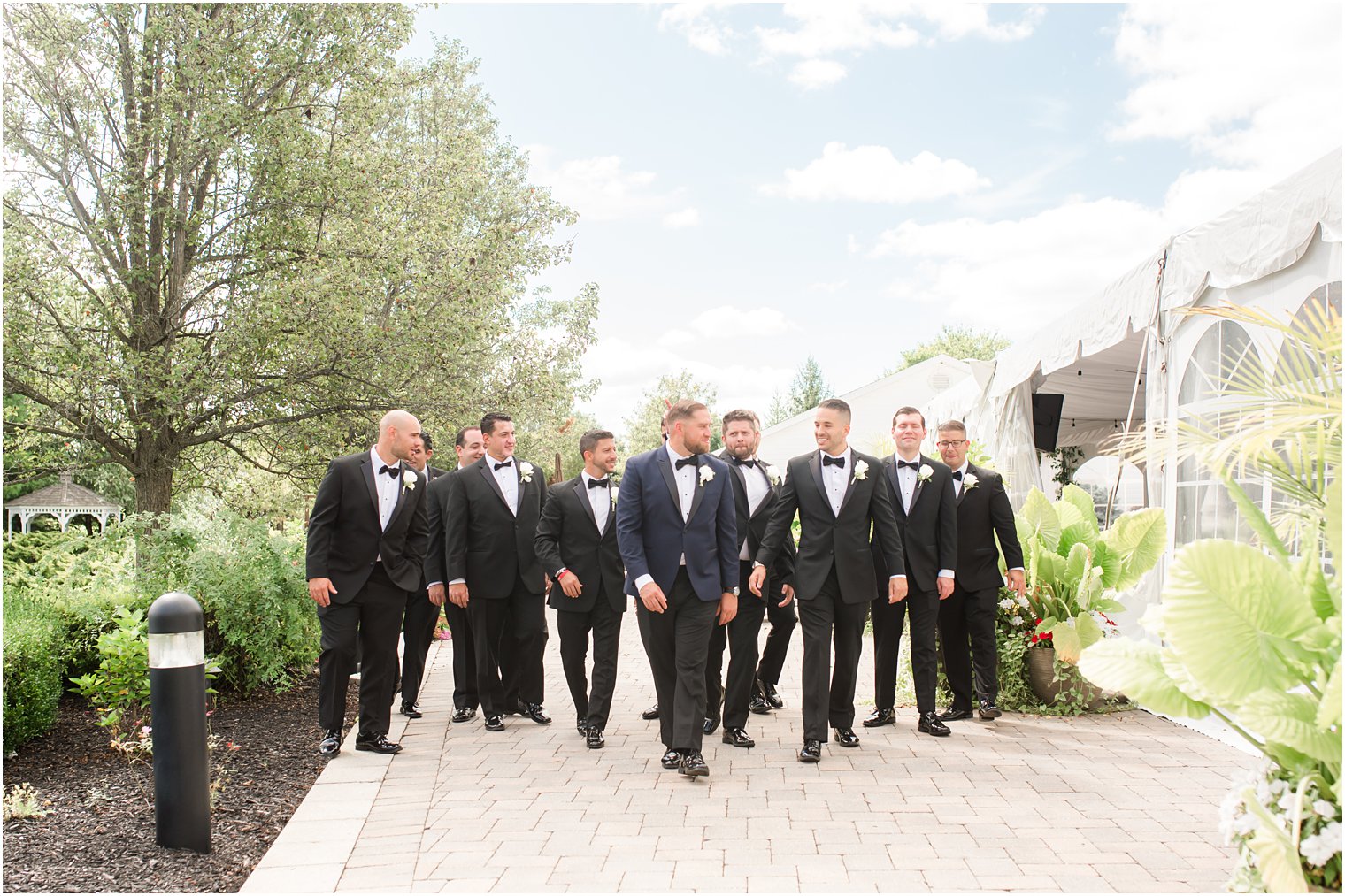 groom and groomsmen walk alongside tent in New Jersey