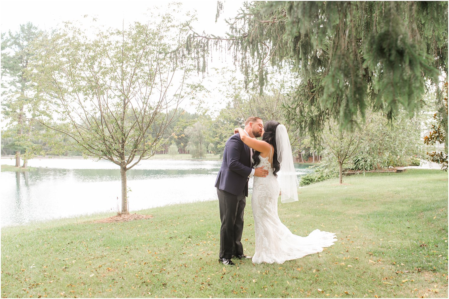 bride and groom kiss by lake in New Jersey