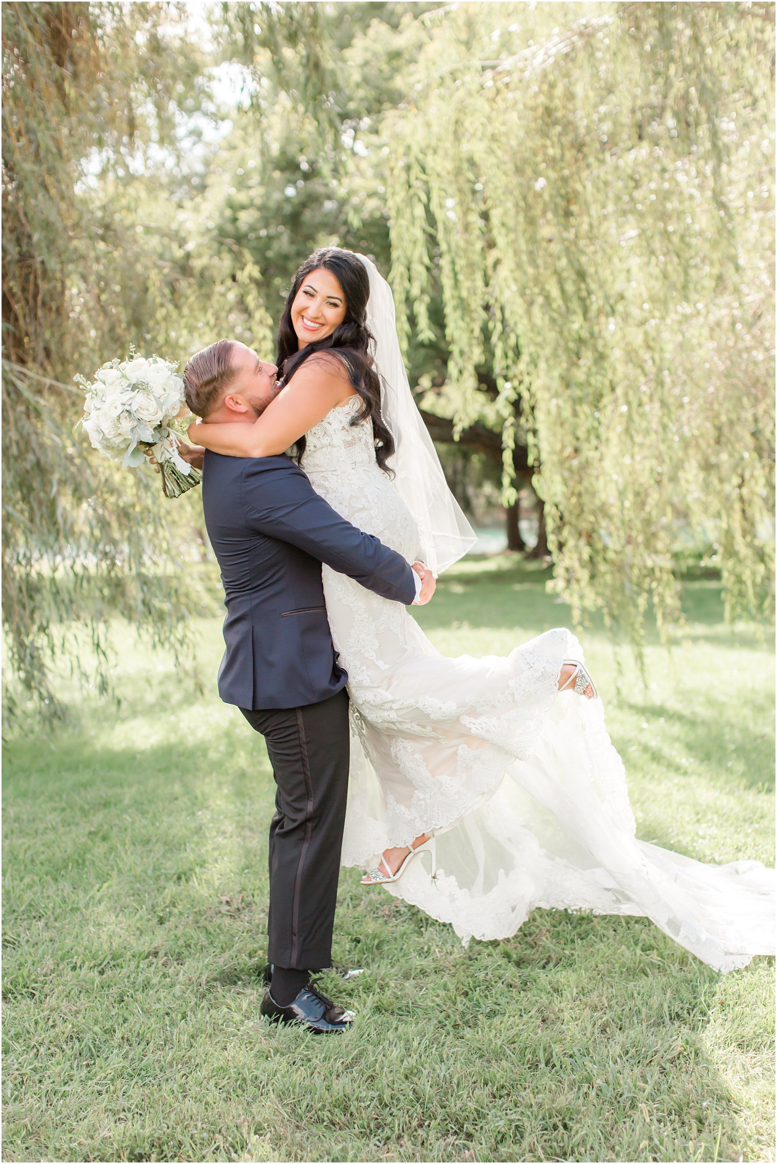 groom lifts bride up during New Jersey wedding portraits
