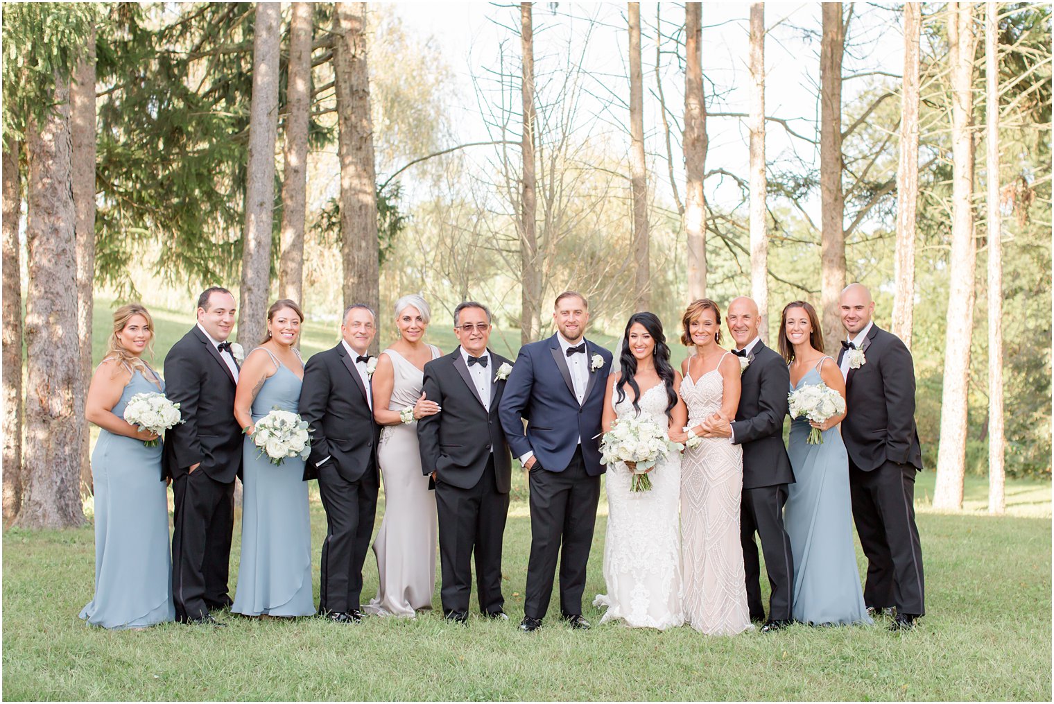 bride and groom pose with family before NJ wedding