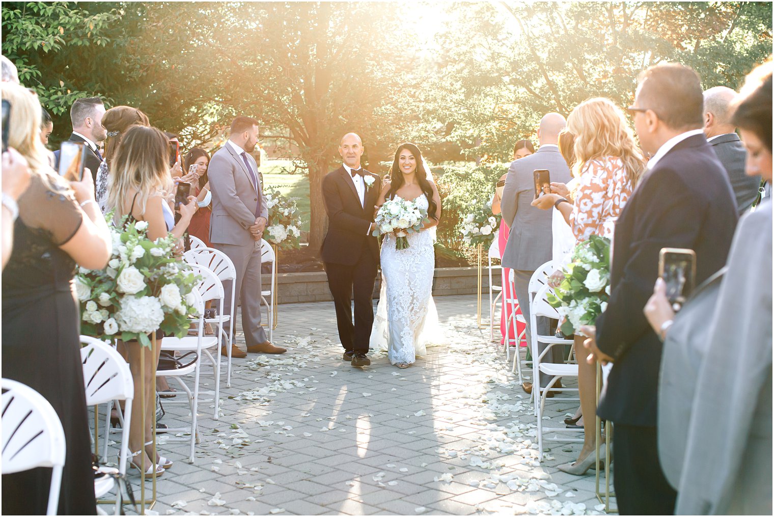 bride walks down aisle with dad at Windows on the Water at Frogbridge