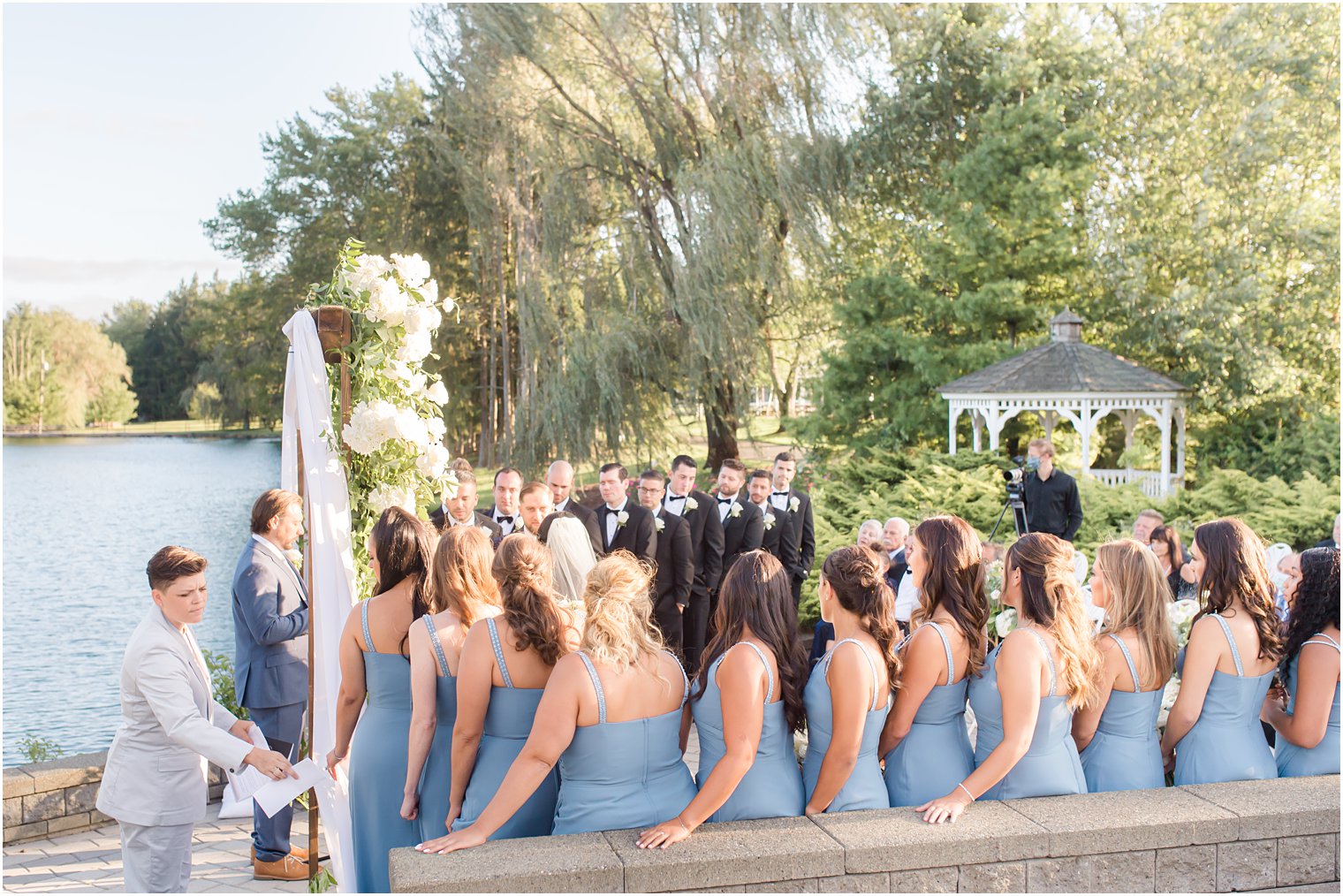 bridal party watches bride and groom during wedding ceremony