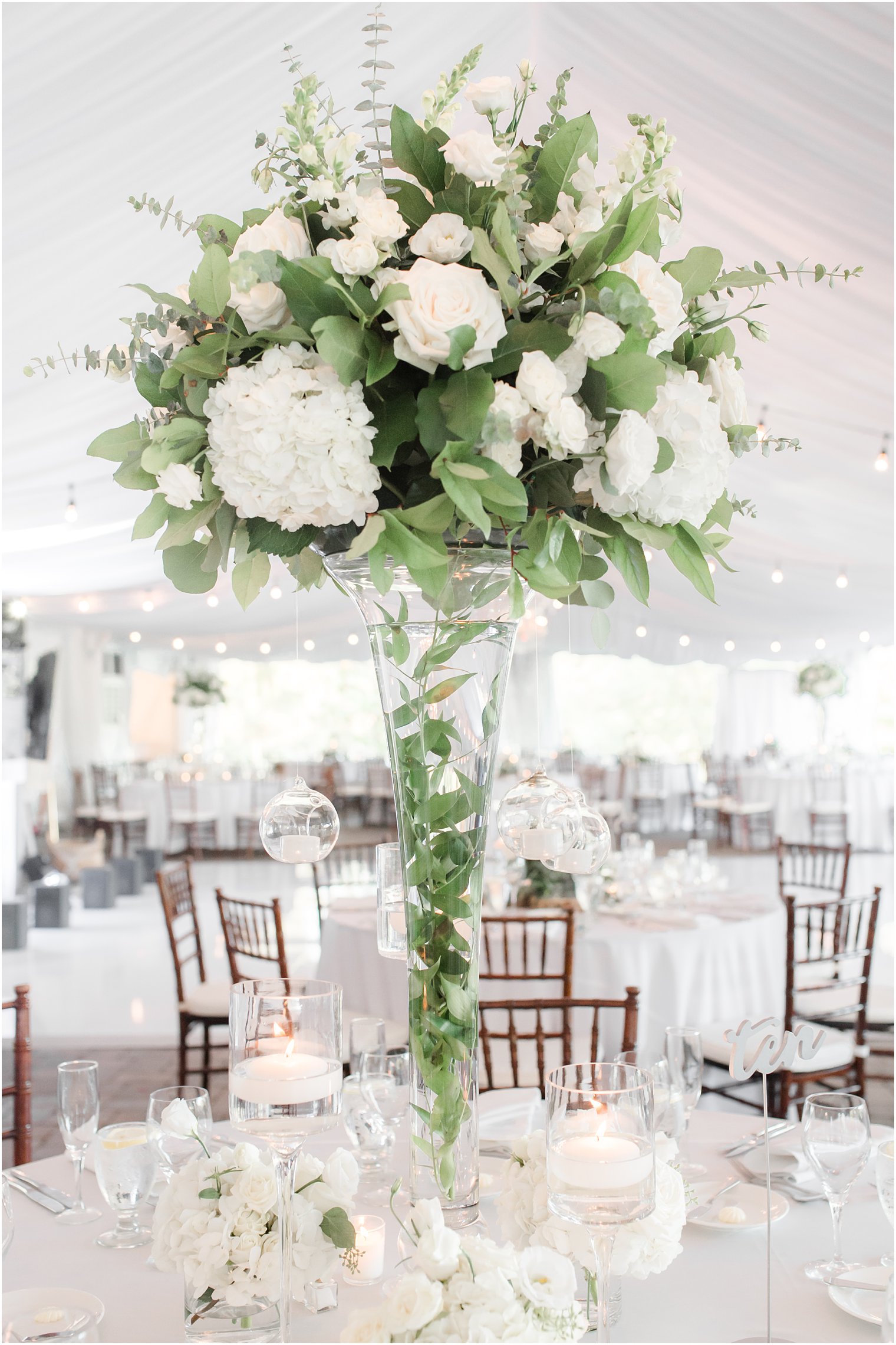 modern wedding centerpiece with white flowers and hanging orbs