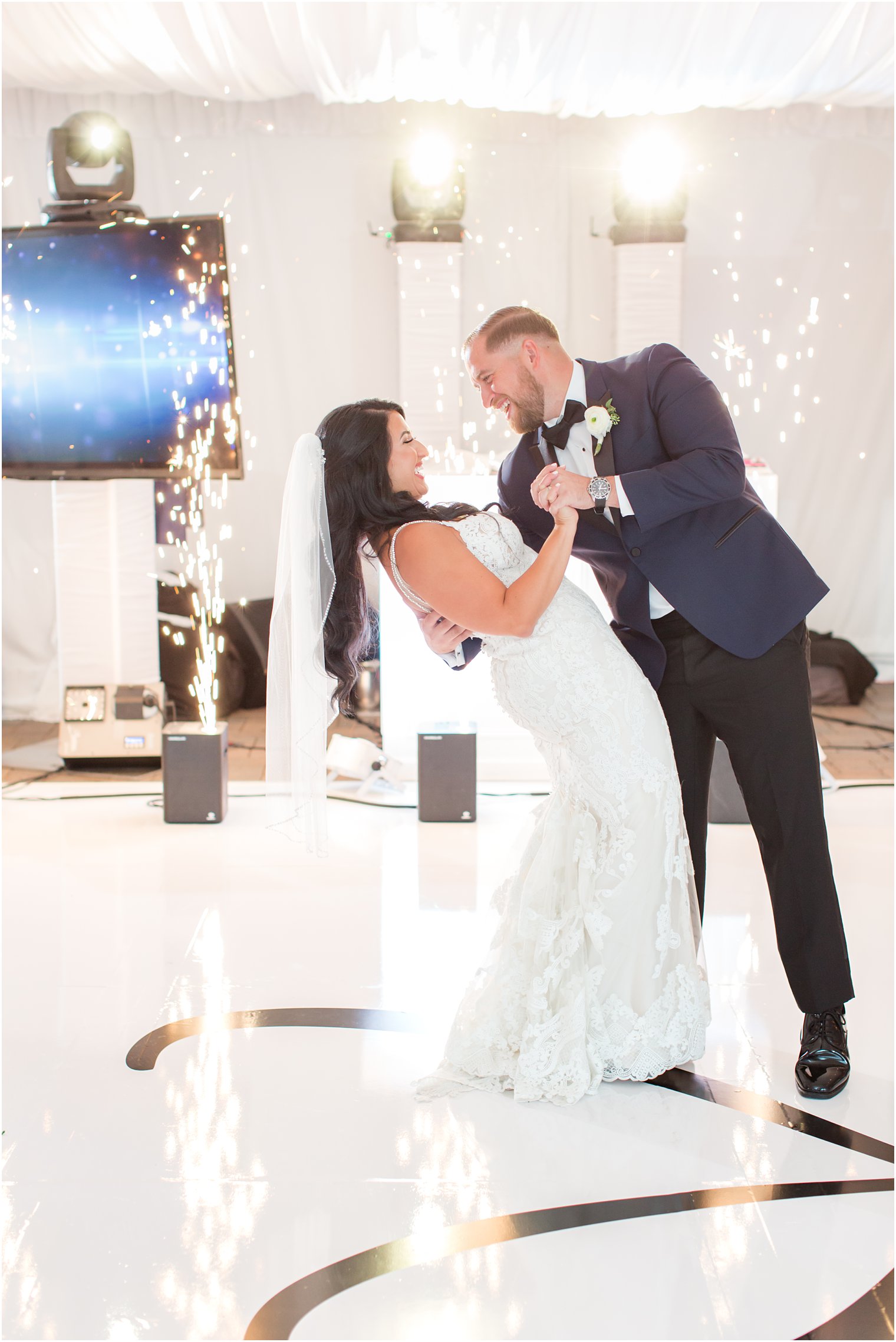 bride and groom dance during reception with fireworks in background