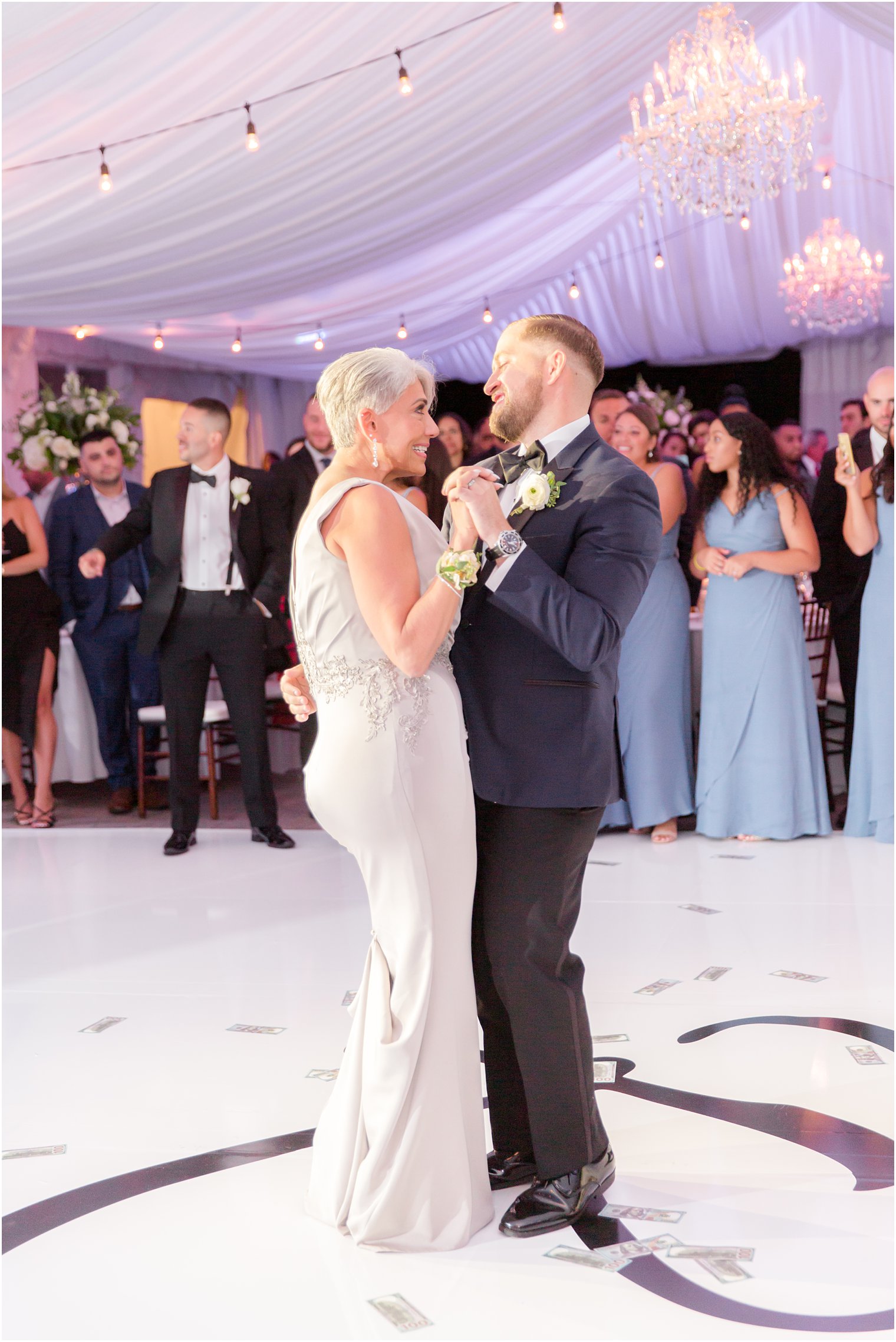 groom dances with mother during tented wedding reception
