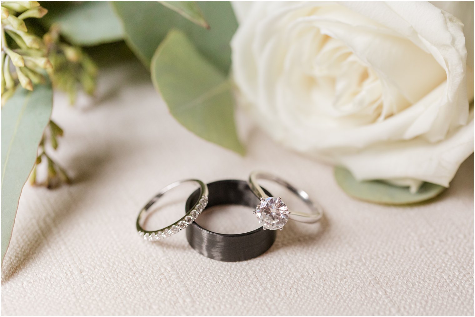 wedding rings lay on cream board during prep for New Jersey