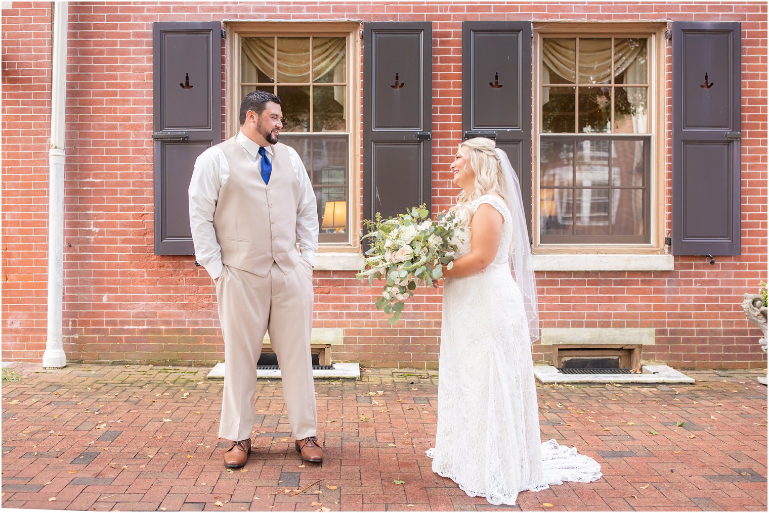 bride and groom smile during first look outside The Lily Inn