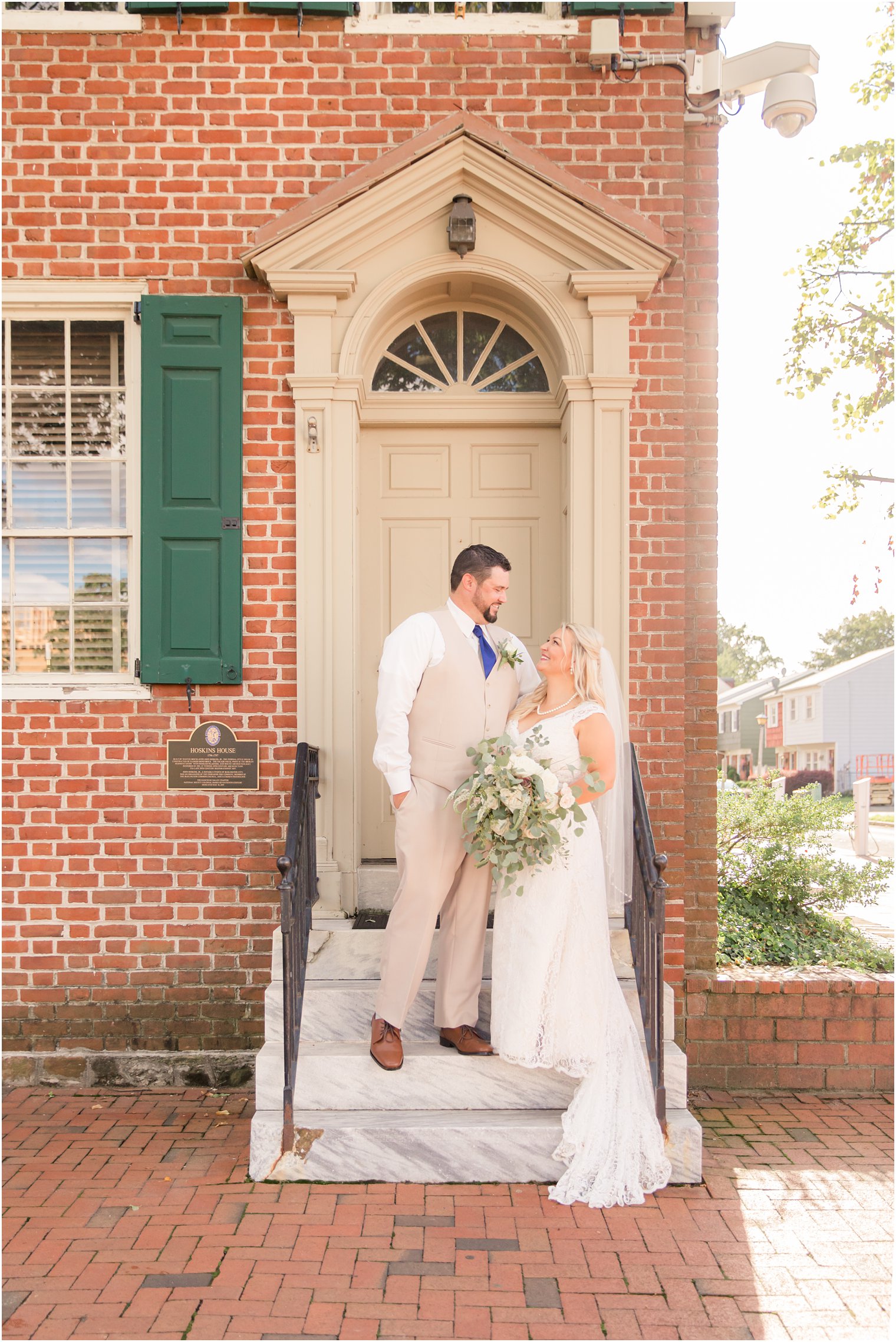 bride and groom pose on the steps of The Lily Inn in NJ