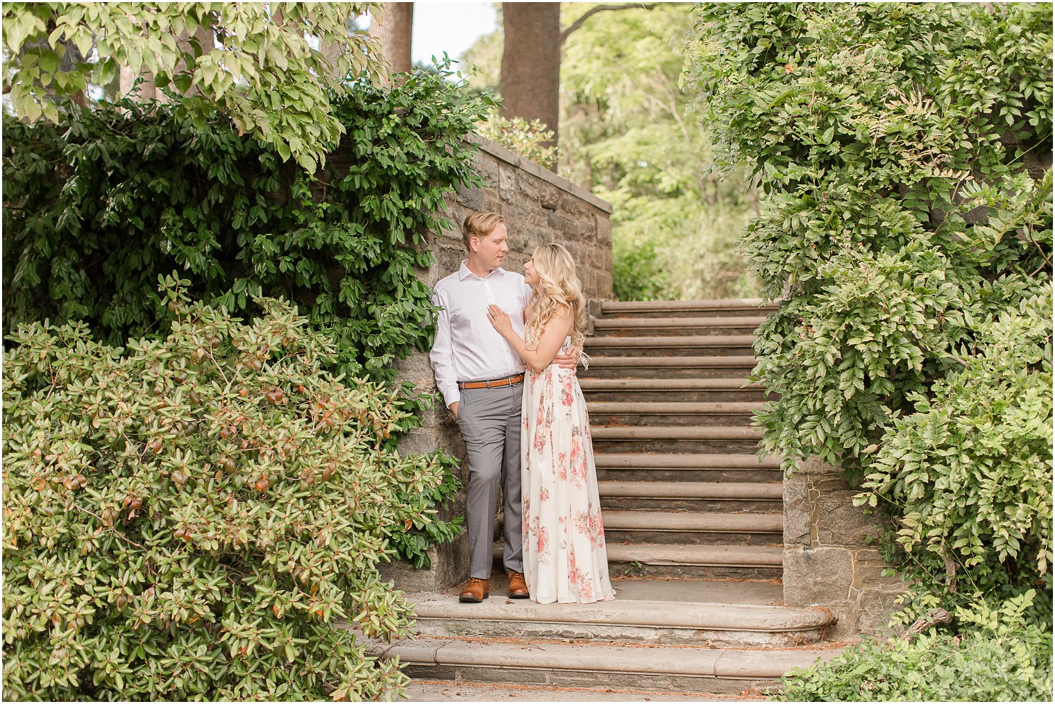 engaged couple poses on steps at Skylands Manor