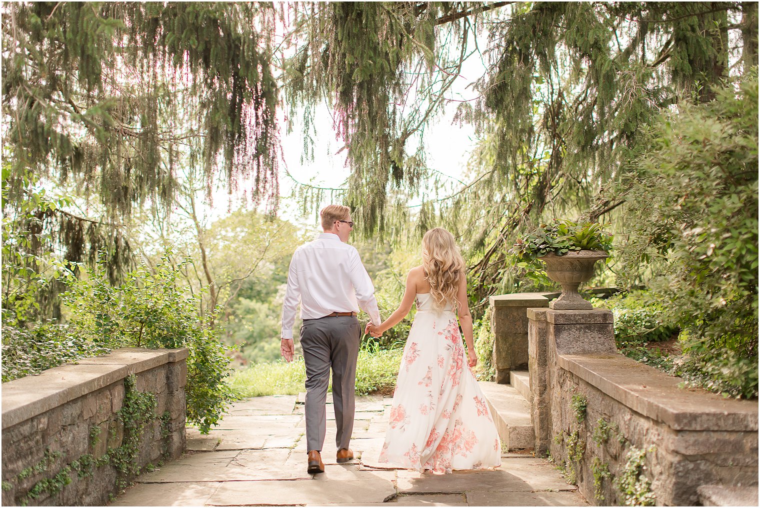 engaged couple walks over bridge at New Jersey wedding venue, Skylands Manor