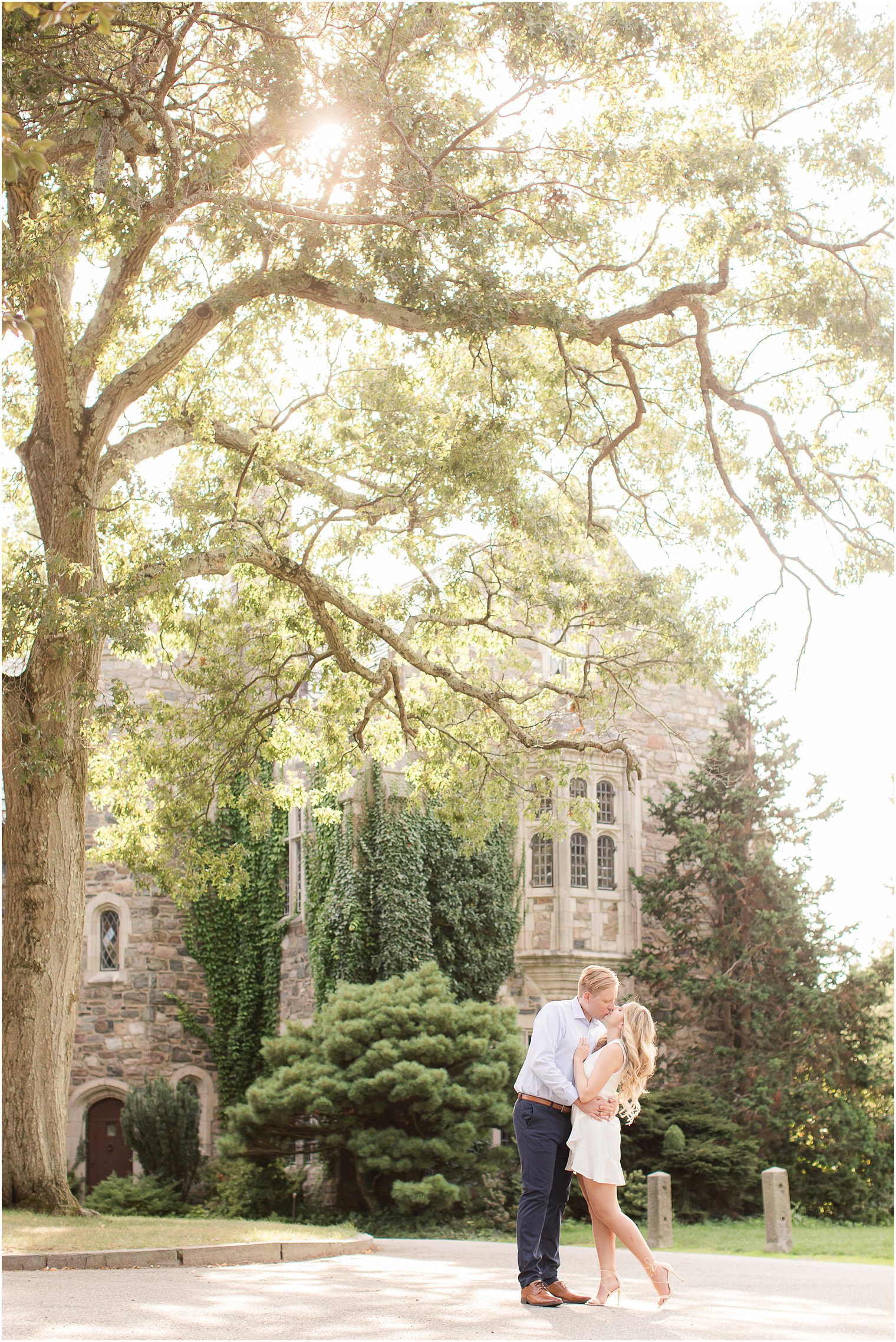 couple kisses in front of Skylands Manor during engagement Session with Idalia Photography