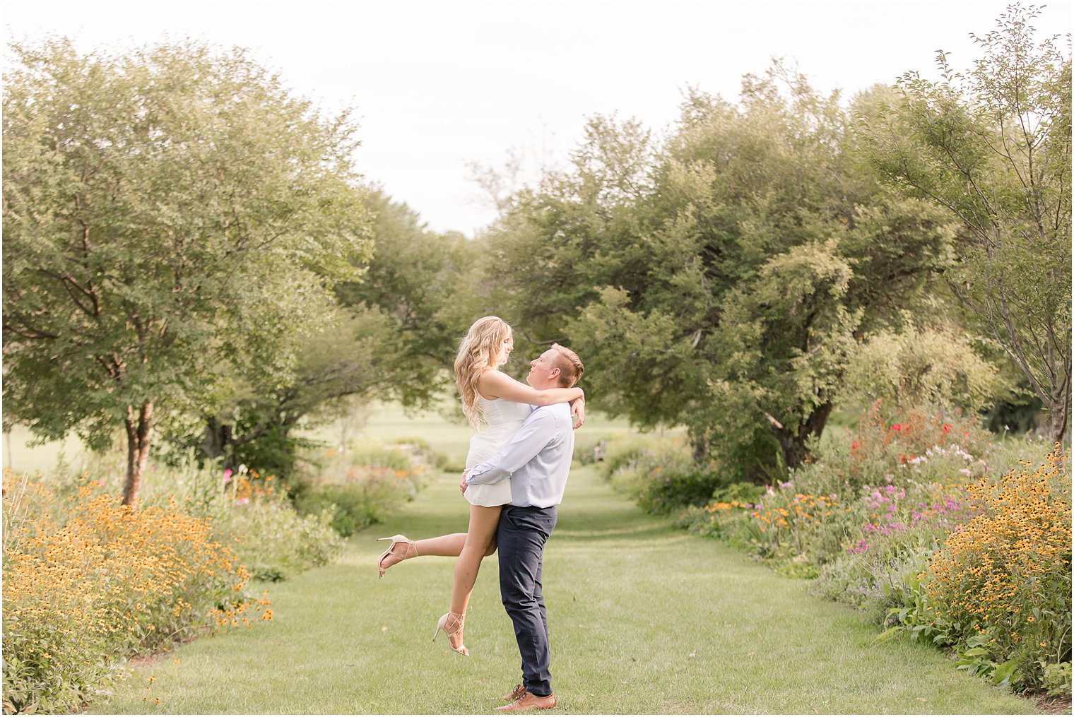 groom lifts bride up during Skylands Manor Engagement Session