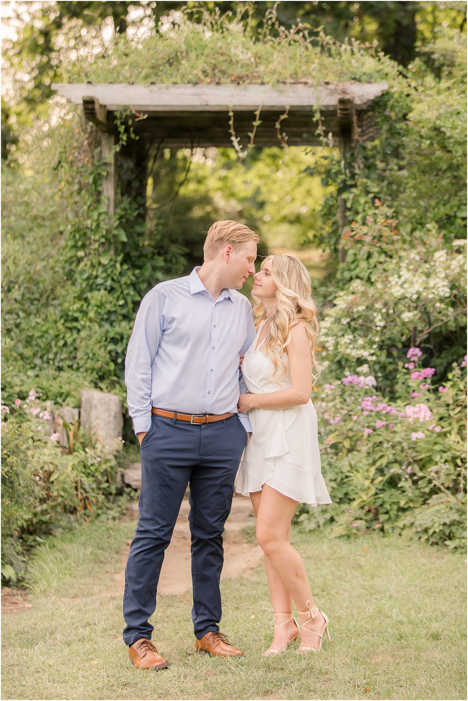 bride holds groom's arm during New Jersey engagement photos