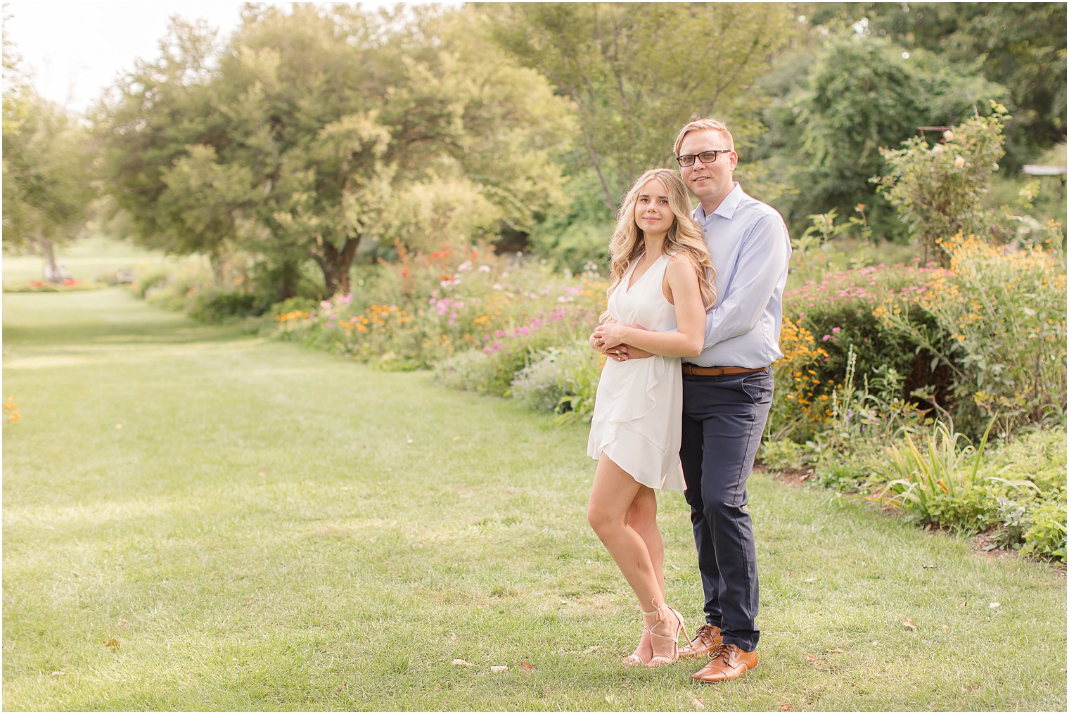 engaged couple poses by gardens in Ringwood NJ