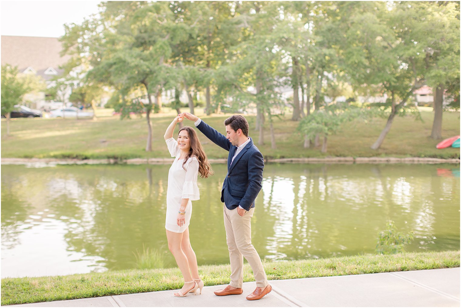 groom twirls bride during engagement session in Spring Lake NJ