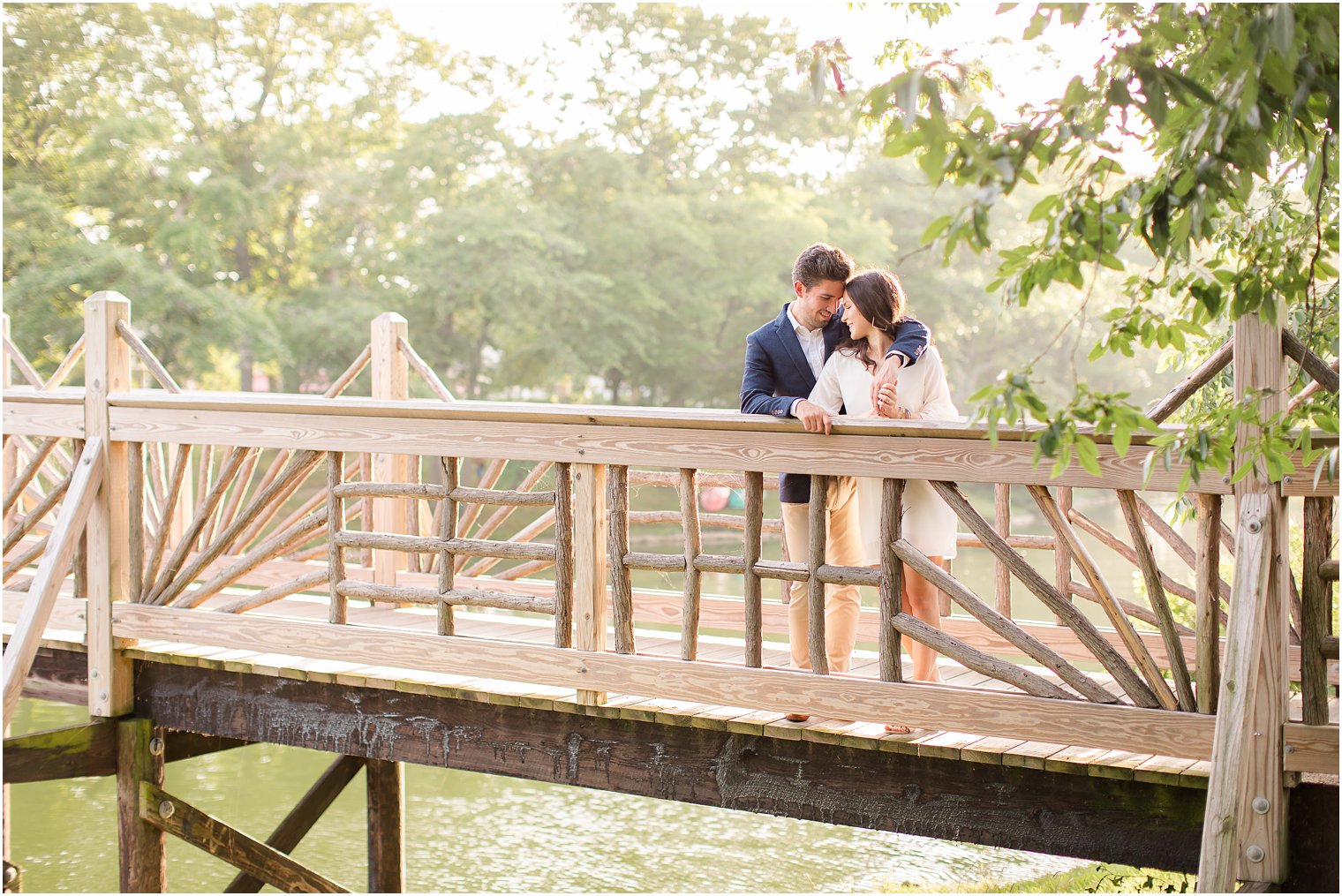 engaged couple poses on wooden bridge during Spring Lake NJ Engagement photos