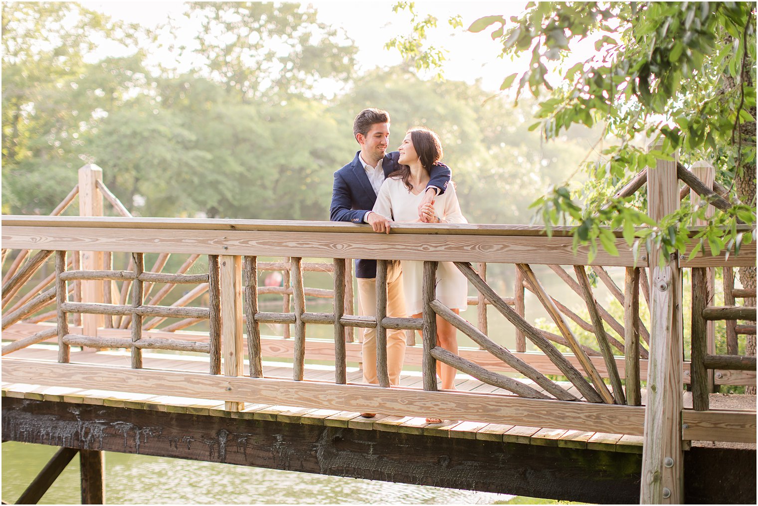 engaged couple poses on bridge during Spring Lake NJ Engagement session