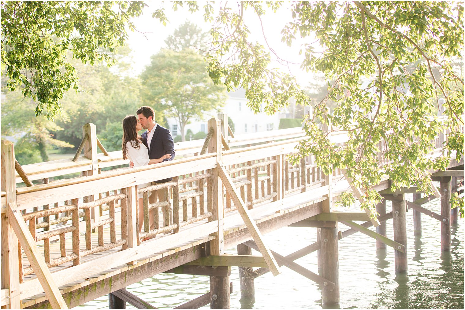 engaged couple kisses on bridge in Spring Lake NJ