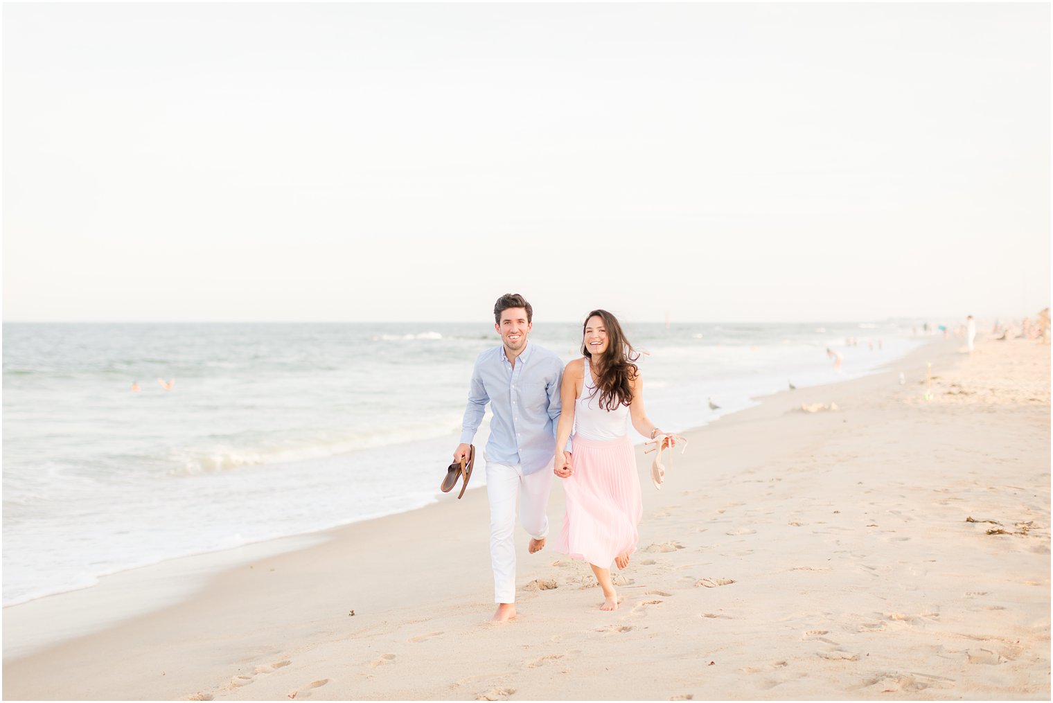 engaged couple runs along New Jersey beach