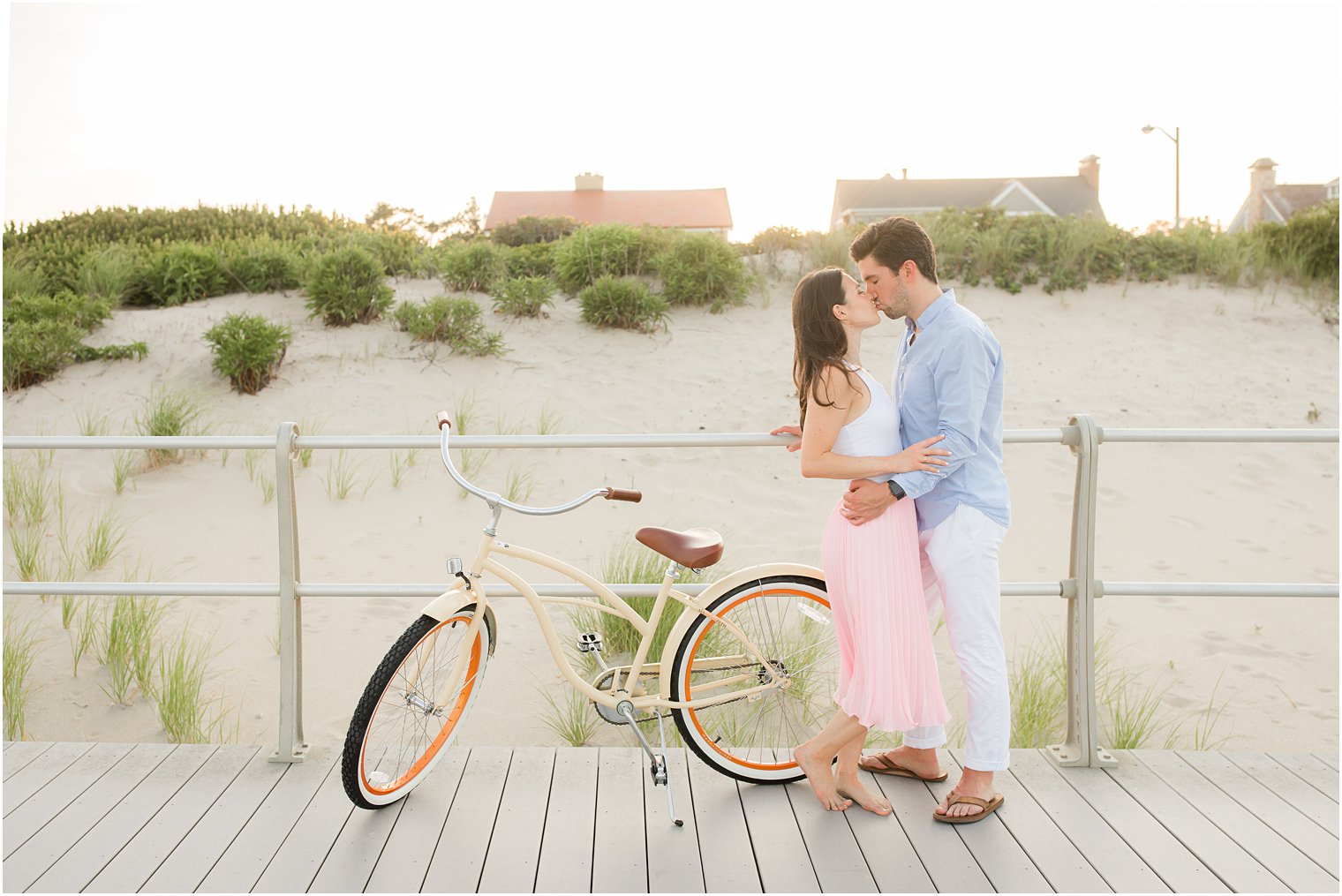couple poses by bike on boardwalk during New Jersey engagement session