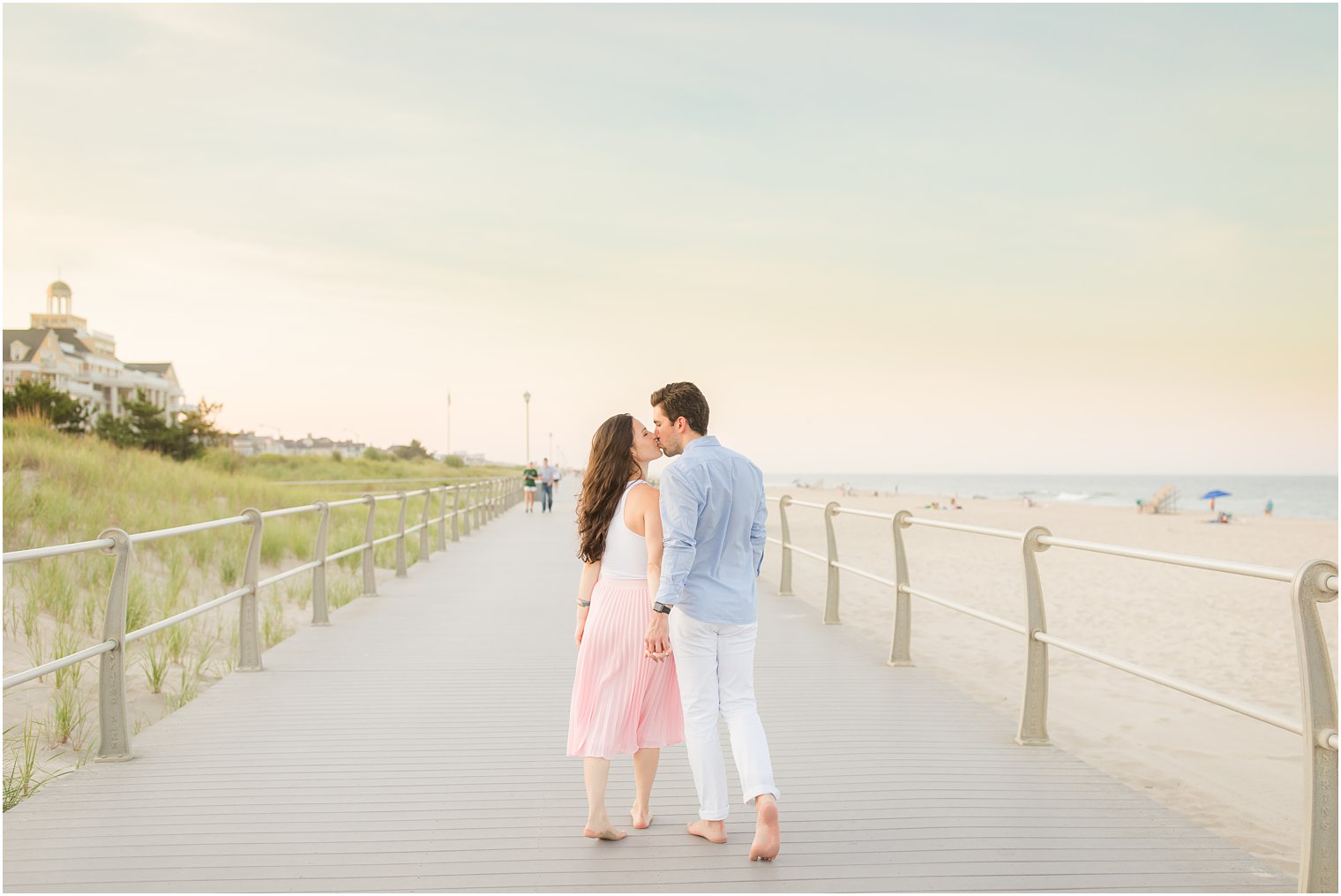 New Jersey couple kisses at sunset on boardwalk in Spring Lake NJ