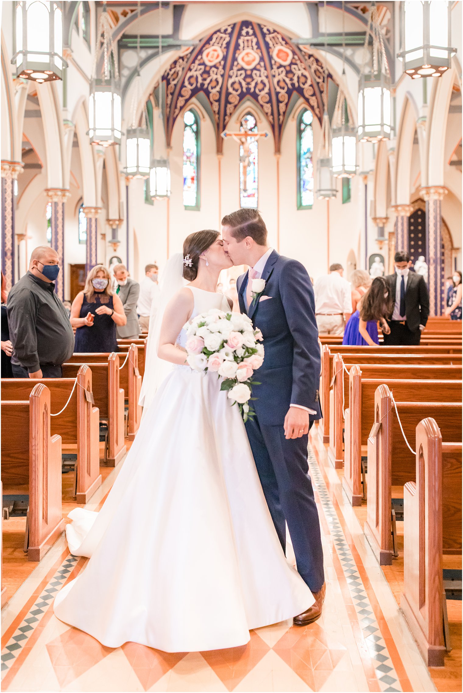 Bride and groom kissing at the aisle at Church of the Assumption in Morristown, NJ