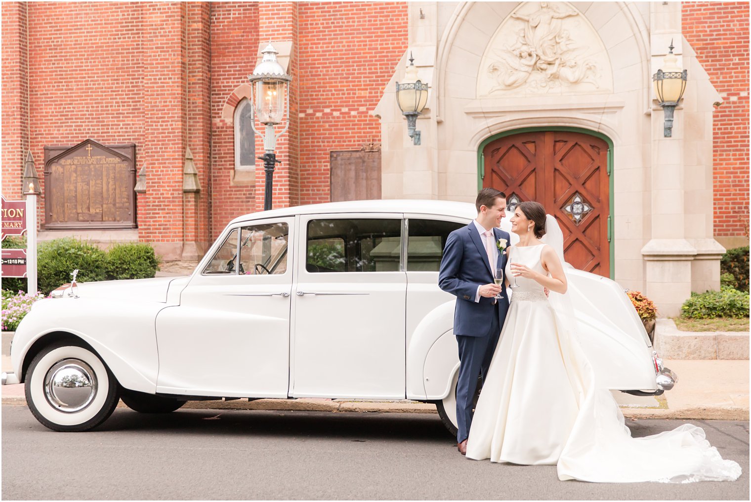 Bride and groom in front of Rolls Royce