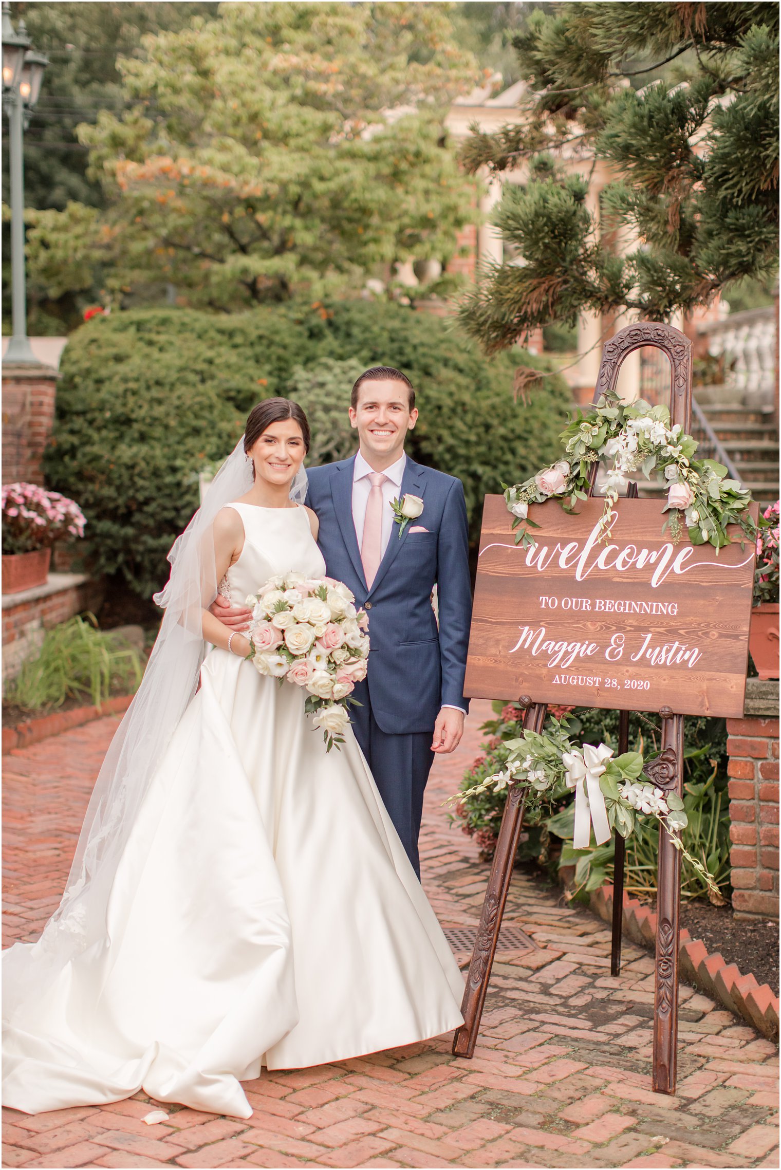Bride and groom with welcome sign at The Manor in West Orange NJ