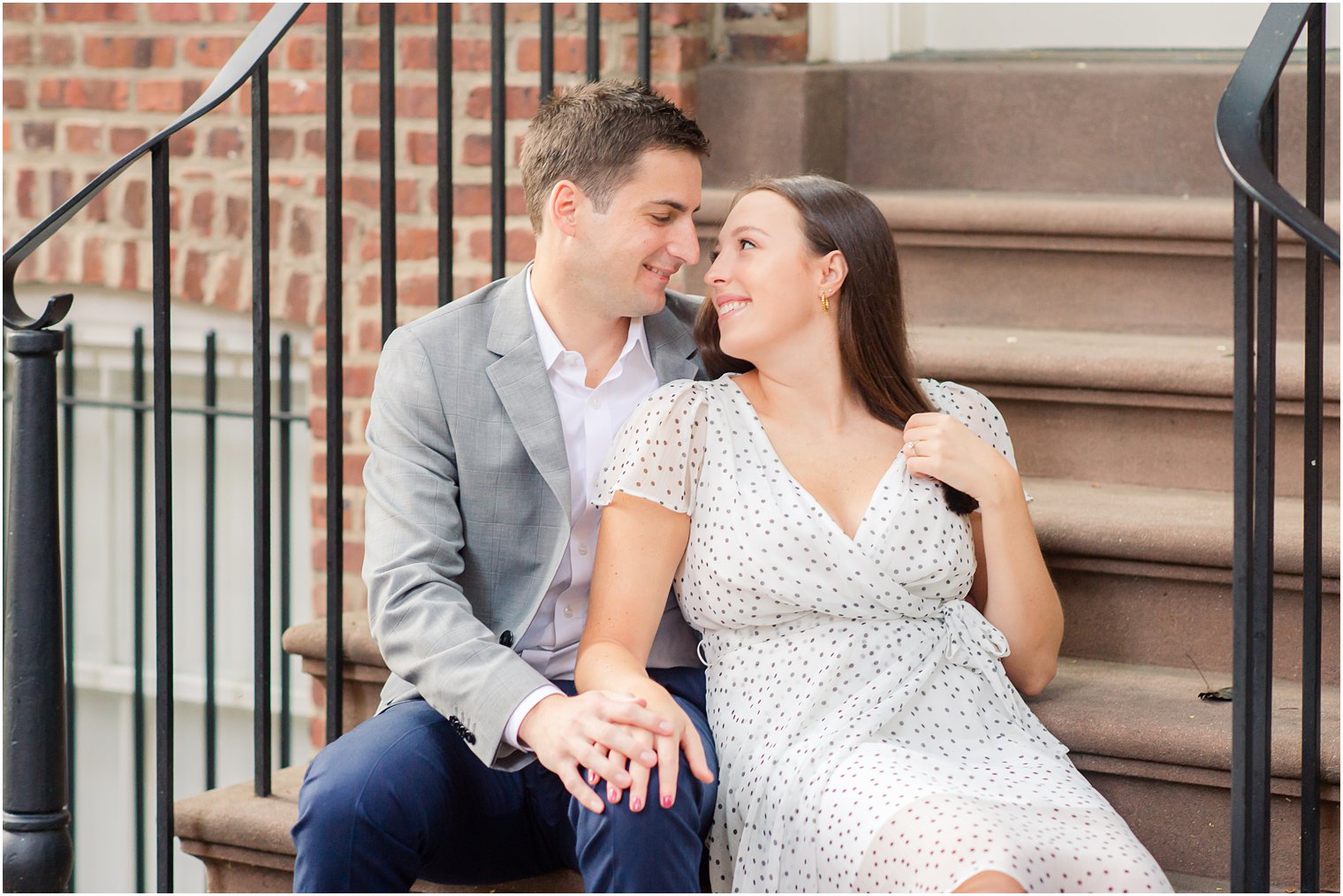 engaged couple sits on New York City steps
