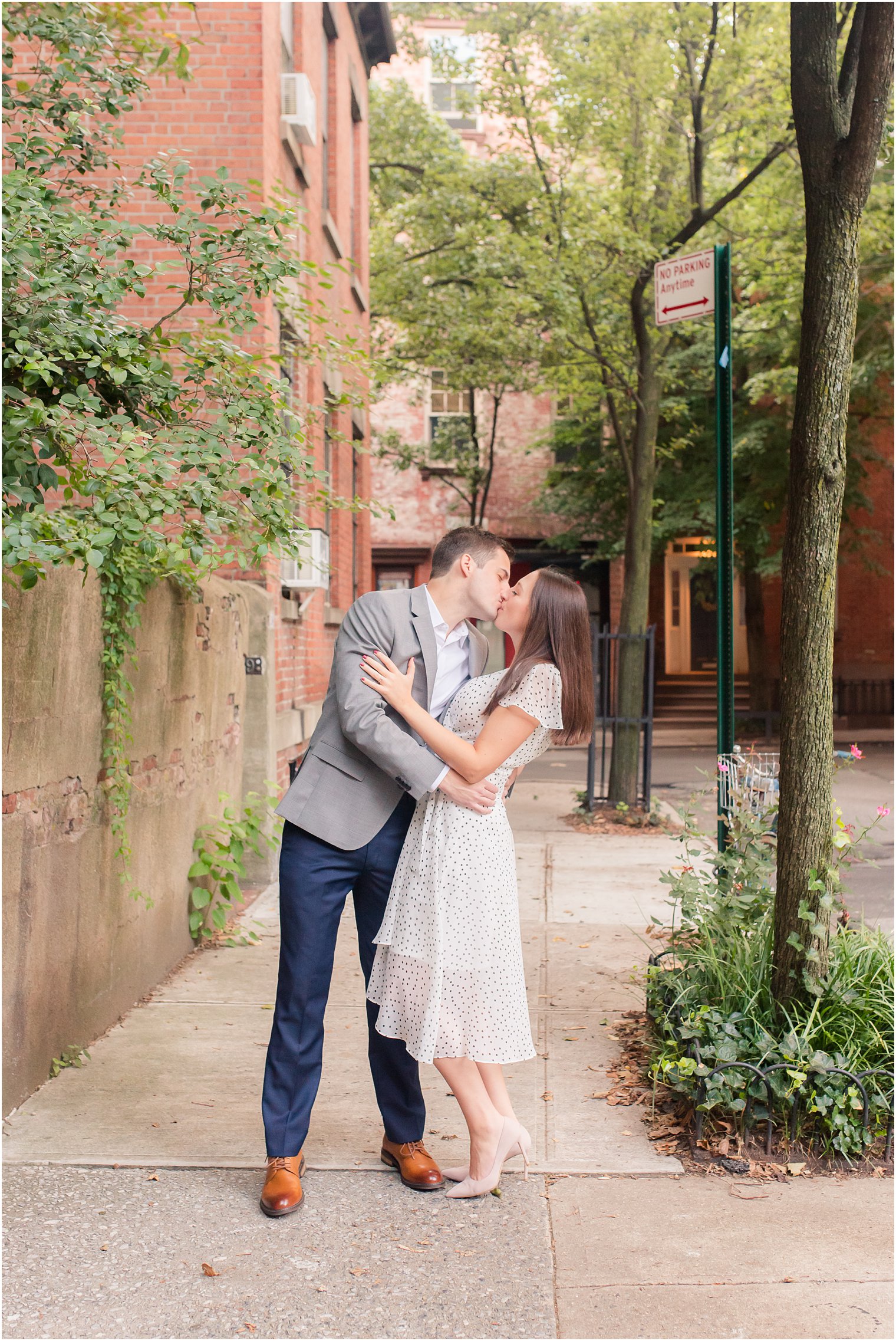 engaged couple kisses on West Village sidewalk in NYC