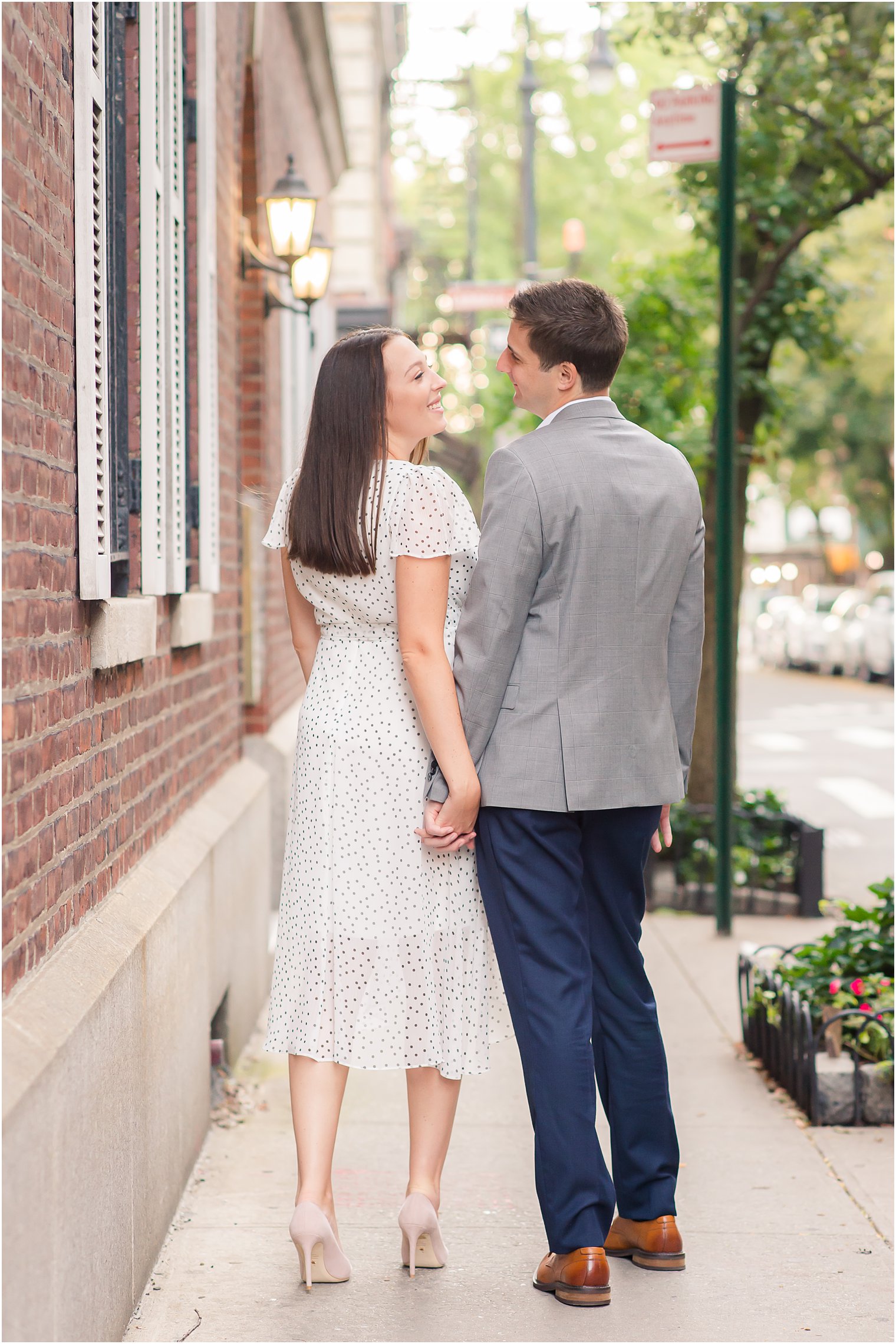 engaged couple holds hands and walks through West Village