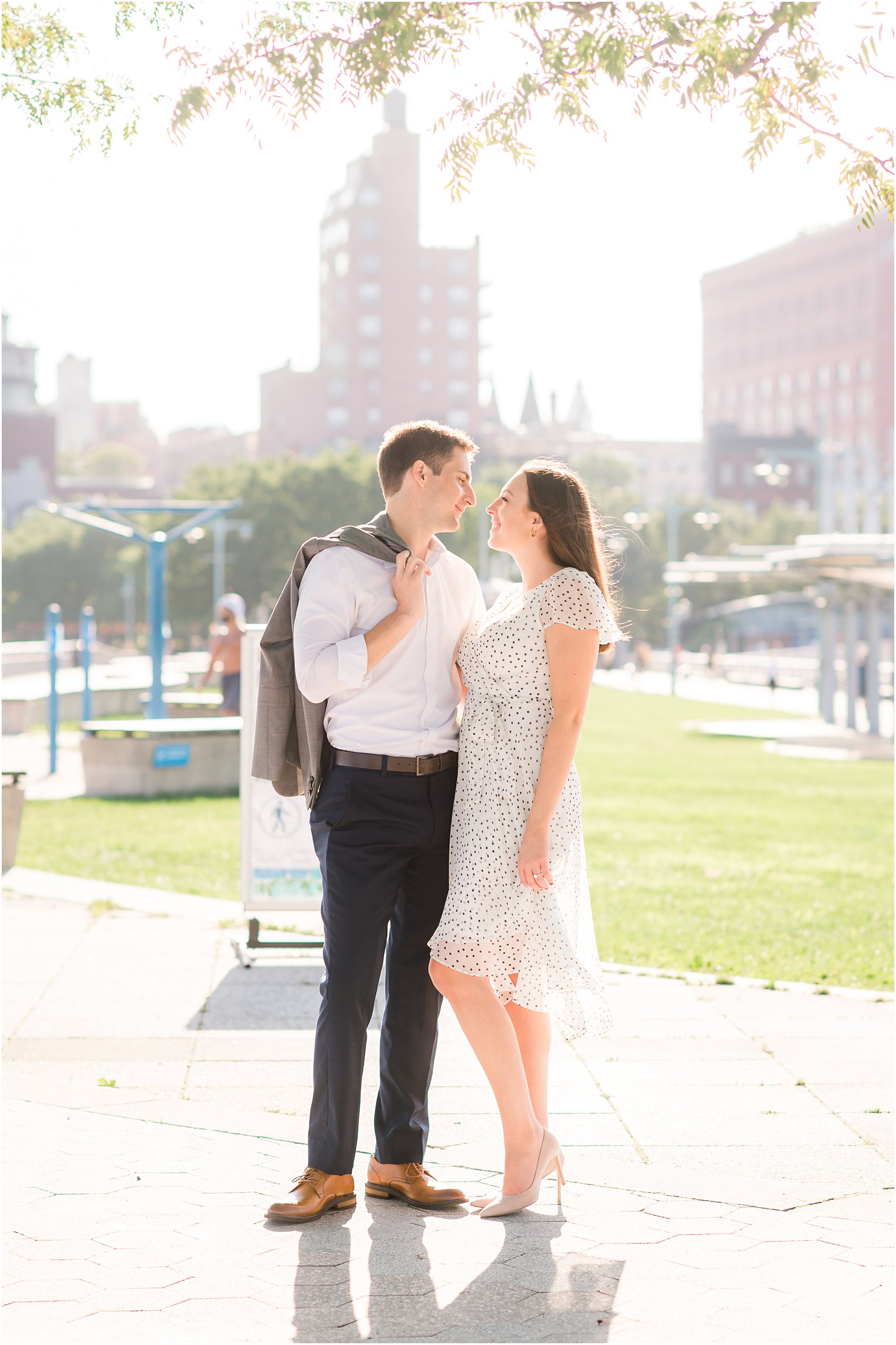 couple poses in front of Manhattan skyline during engagement photos