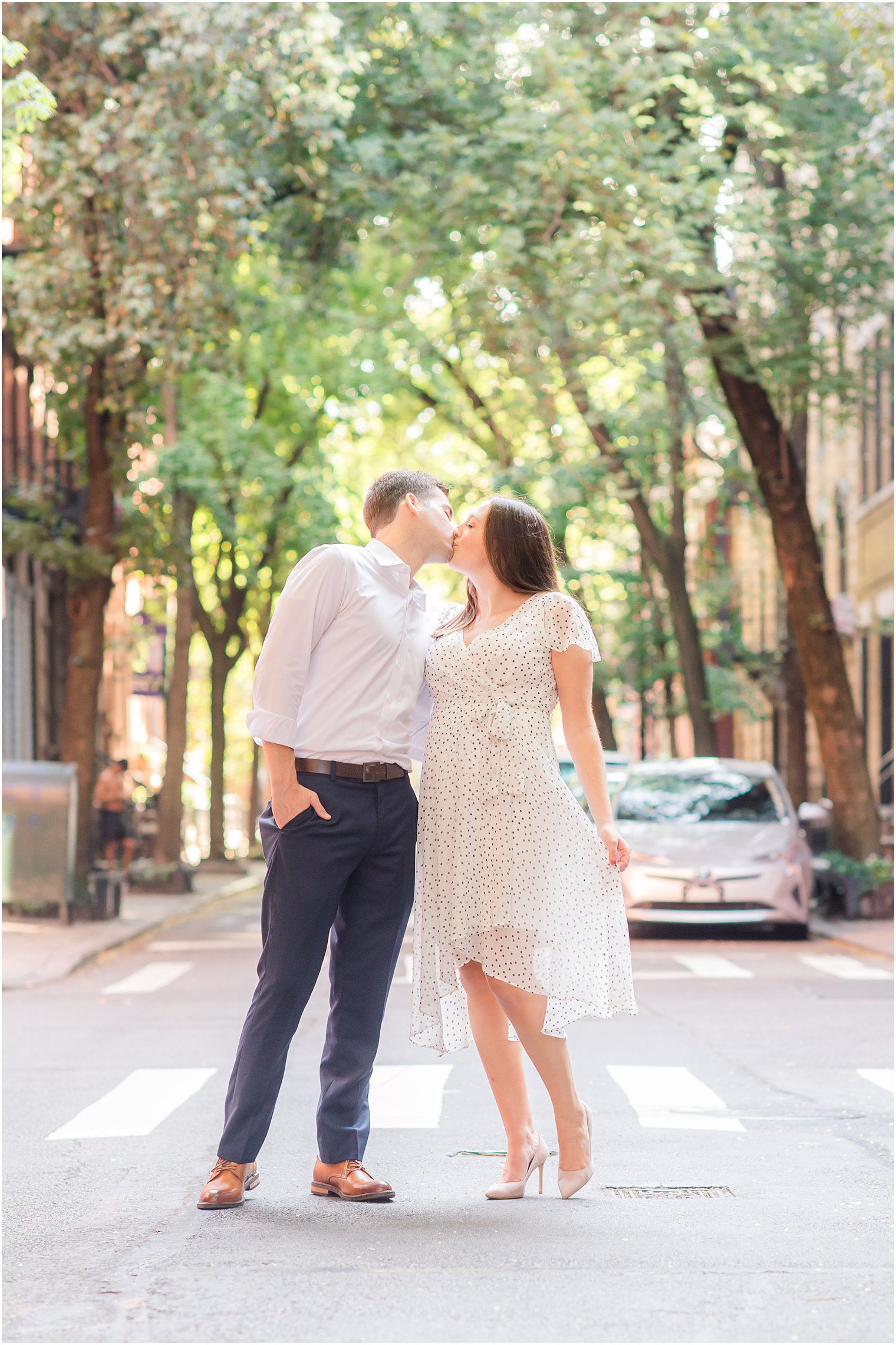 engaged couple poses in New York City street during engagement session