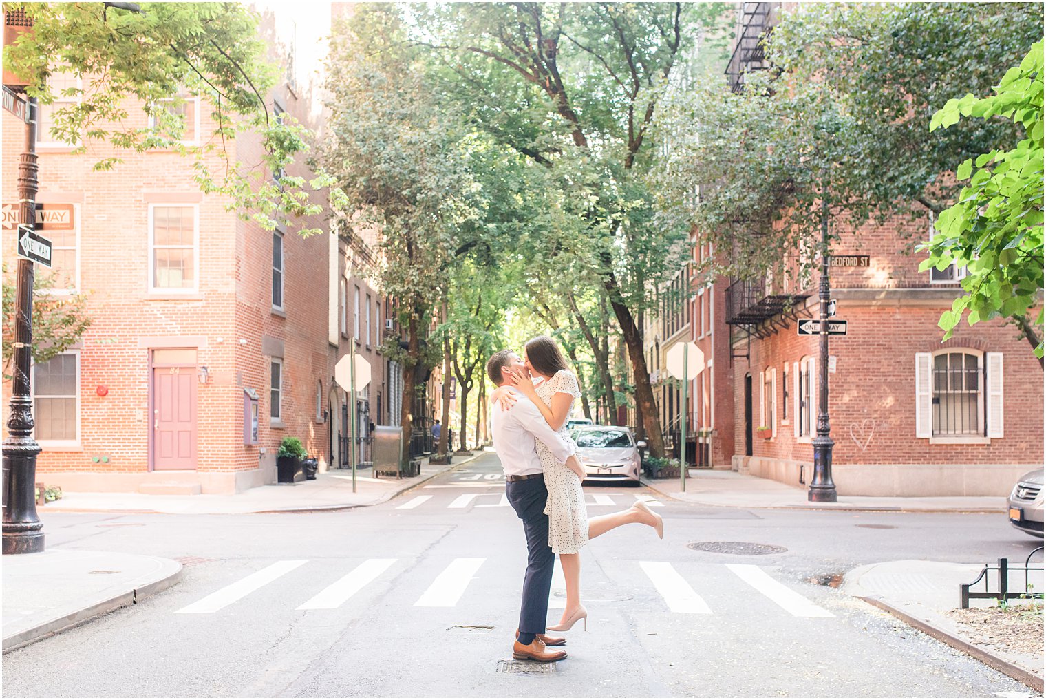 groom lifts bride on Manhattan street crosswalk during West Village Engagement Photos