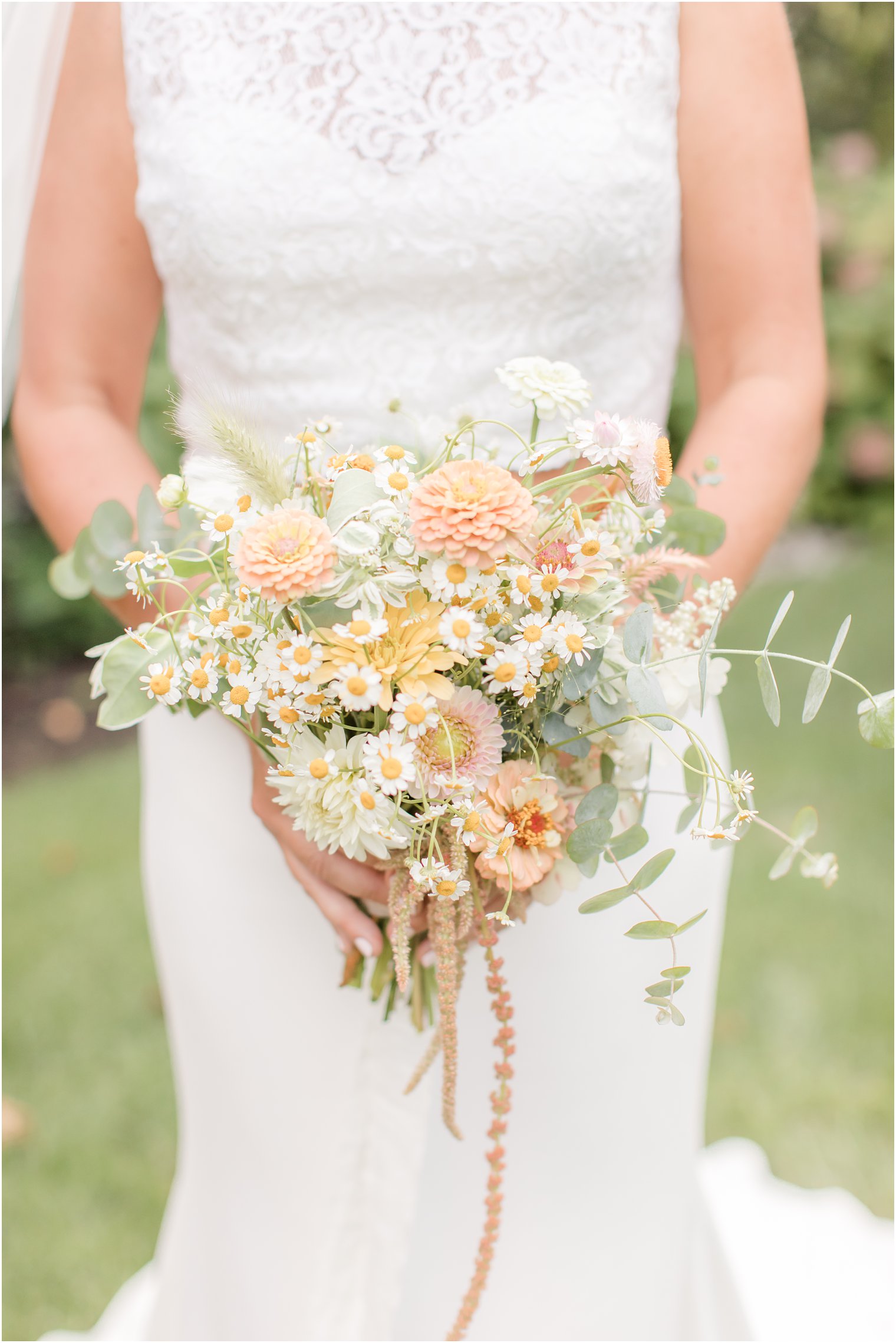 bride holds rustic wedding bouquet of peach wildflowers
