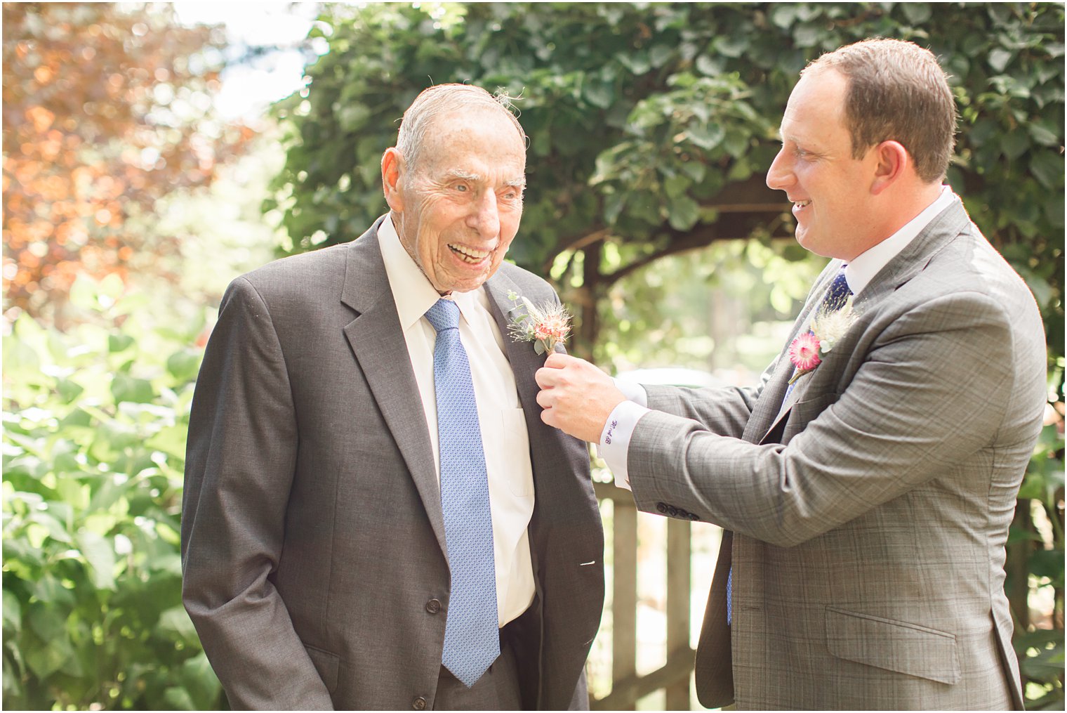 groom helps grandfather with boutonnière 