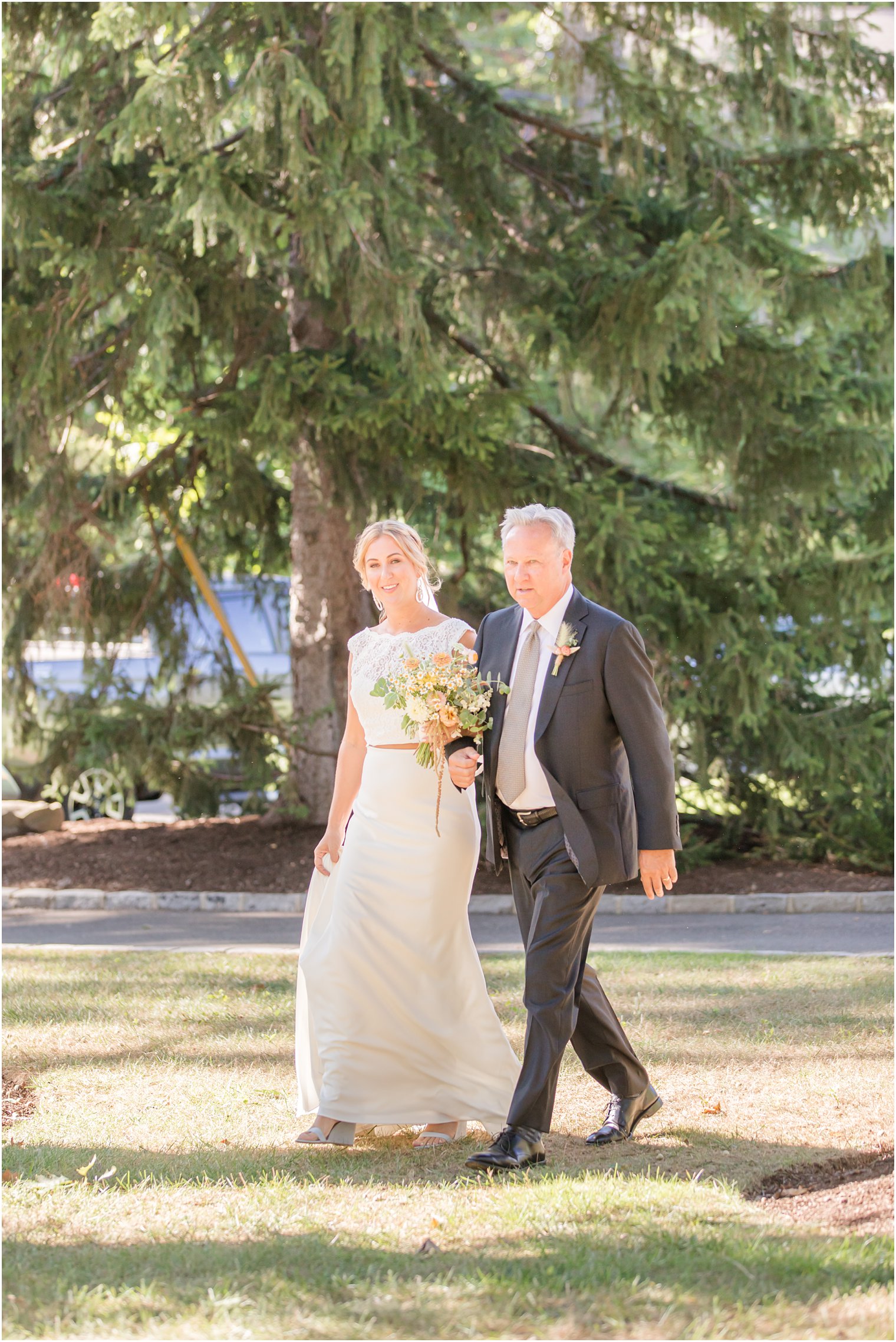 bride walks into backyard wedding with dad