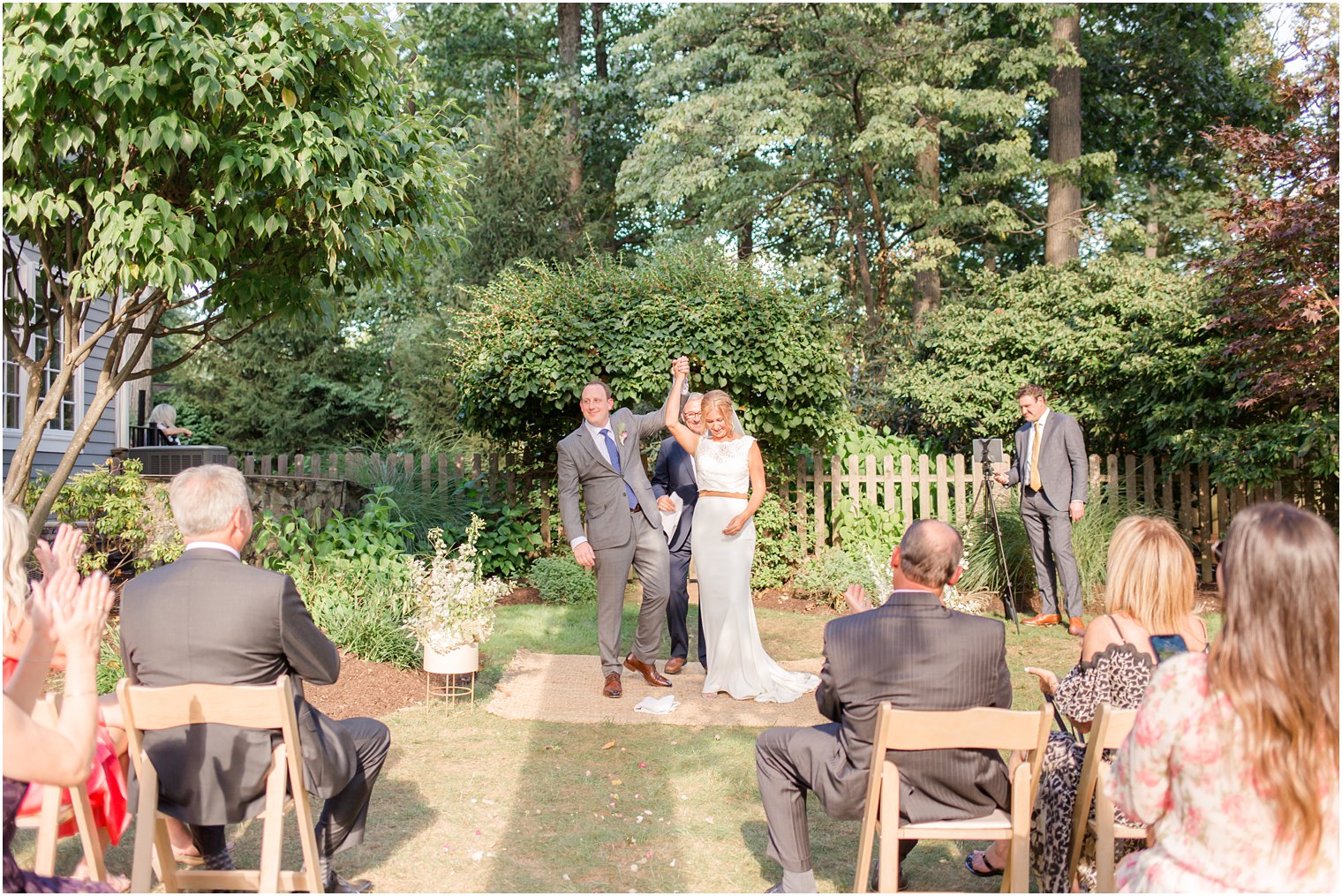 bride and groom cheer during wedding ceremony in backyard