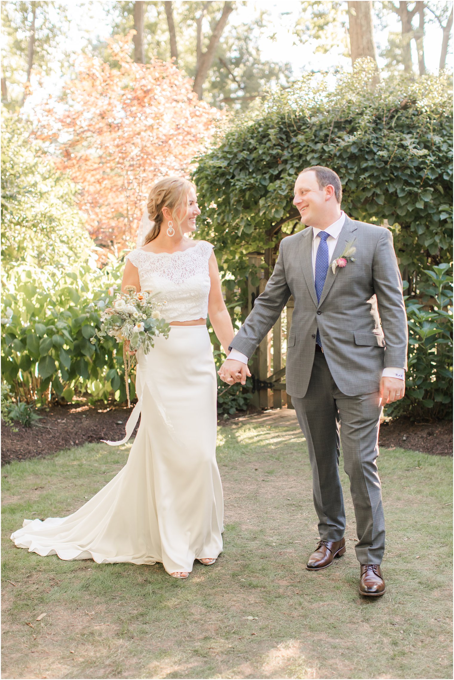 newlyweds walk through backyard after NJ wedding