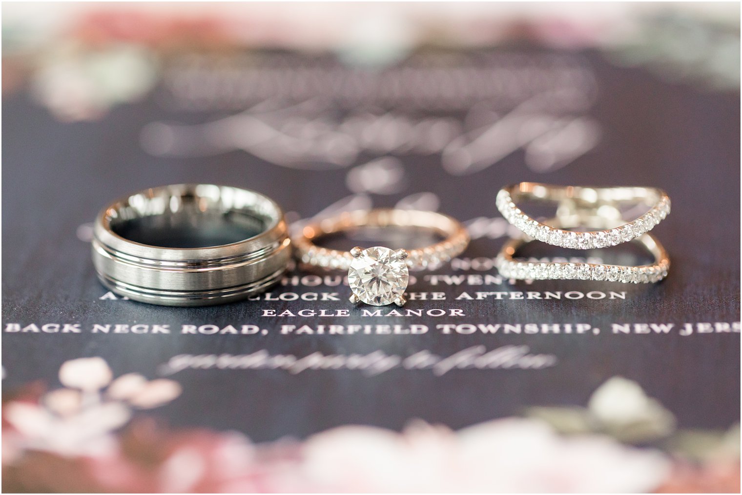 engagement rings rest on navy blue stationery