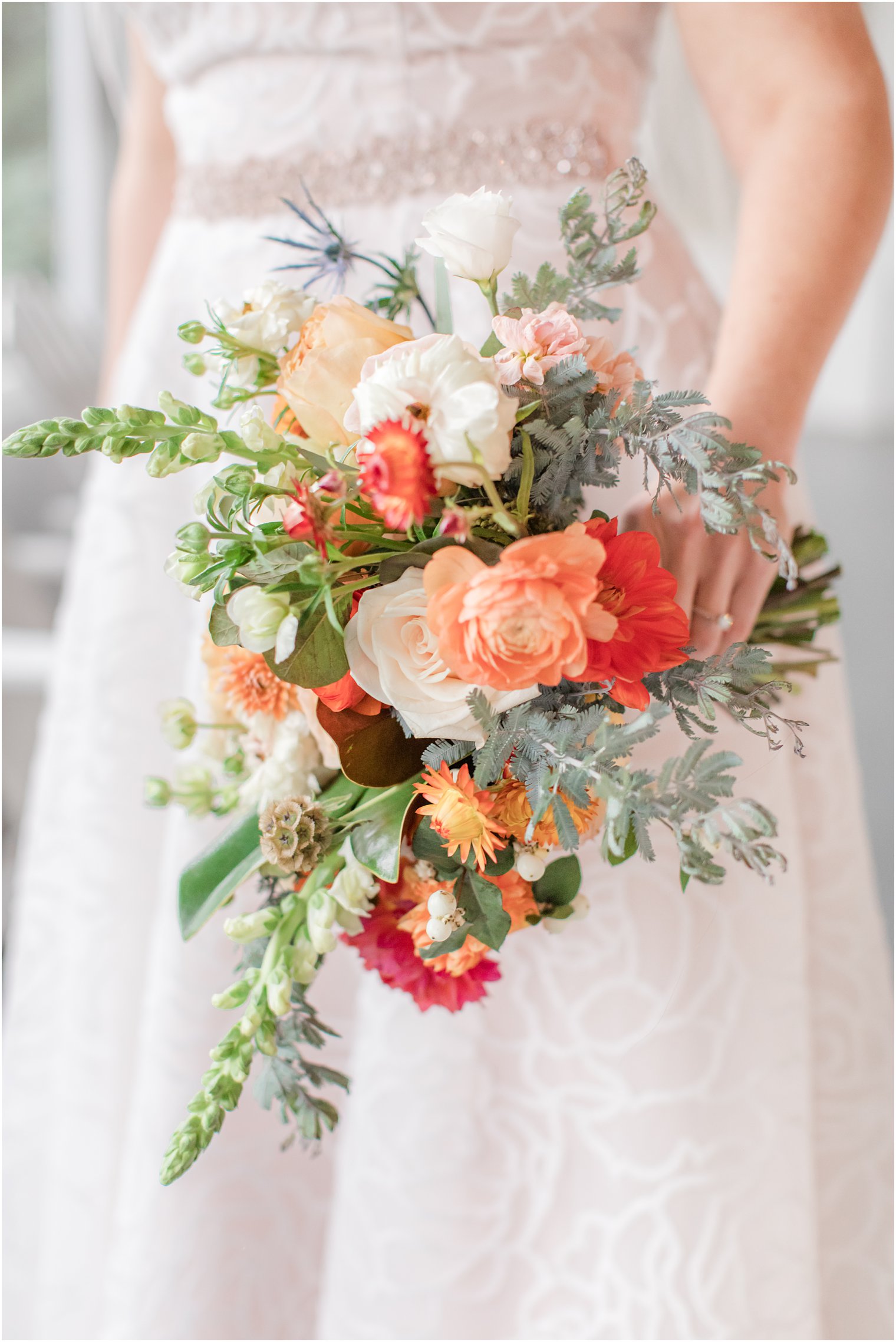 bride holds fall bouquet by Leigh Florist