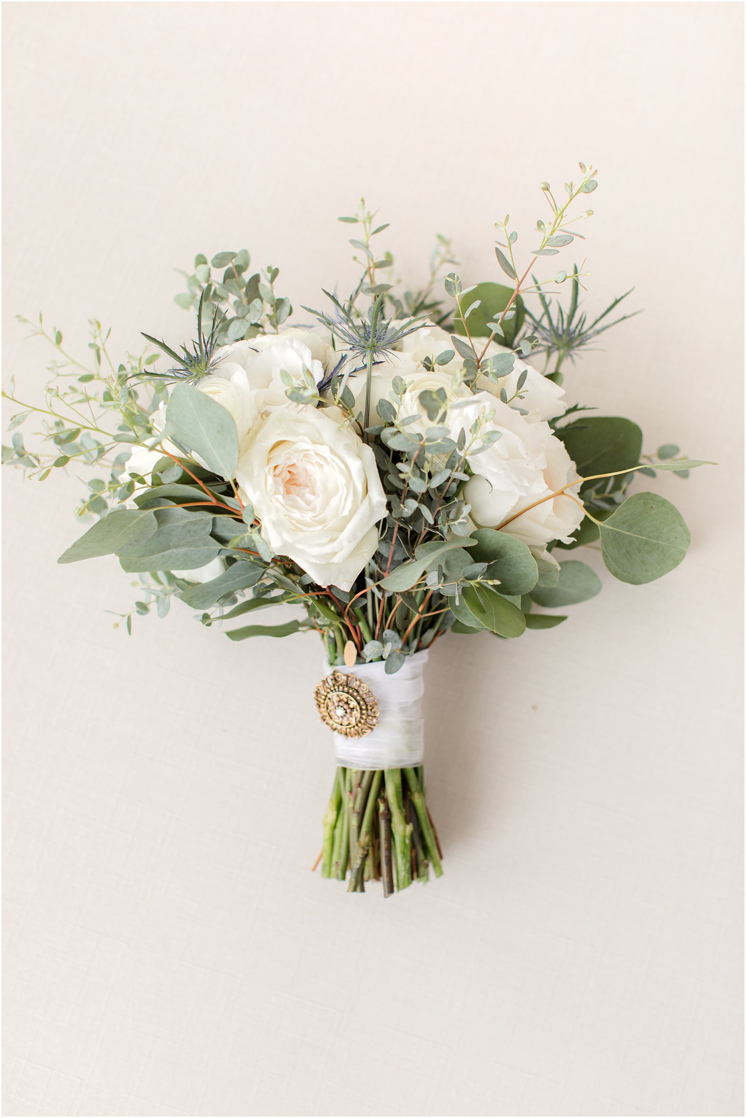 wedding bouquet of white roses with greenery