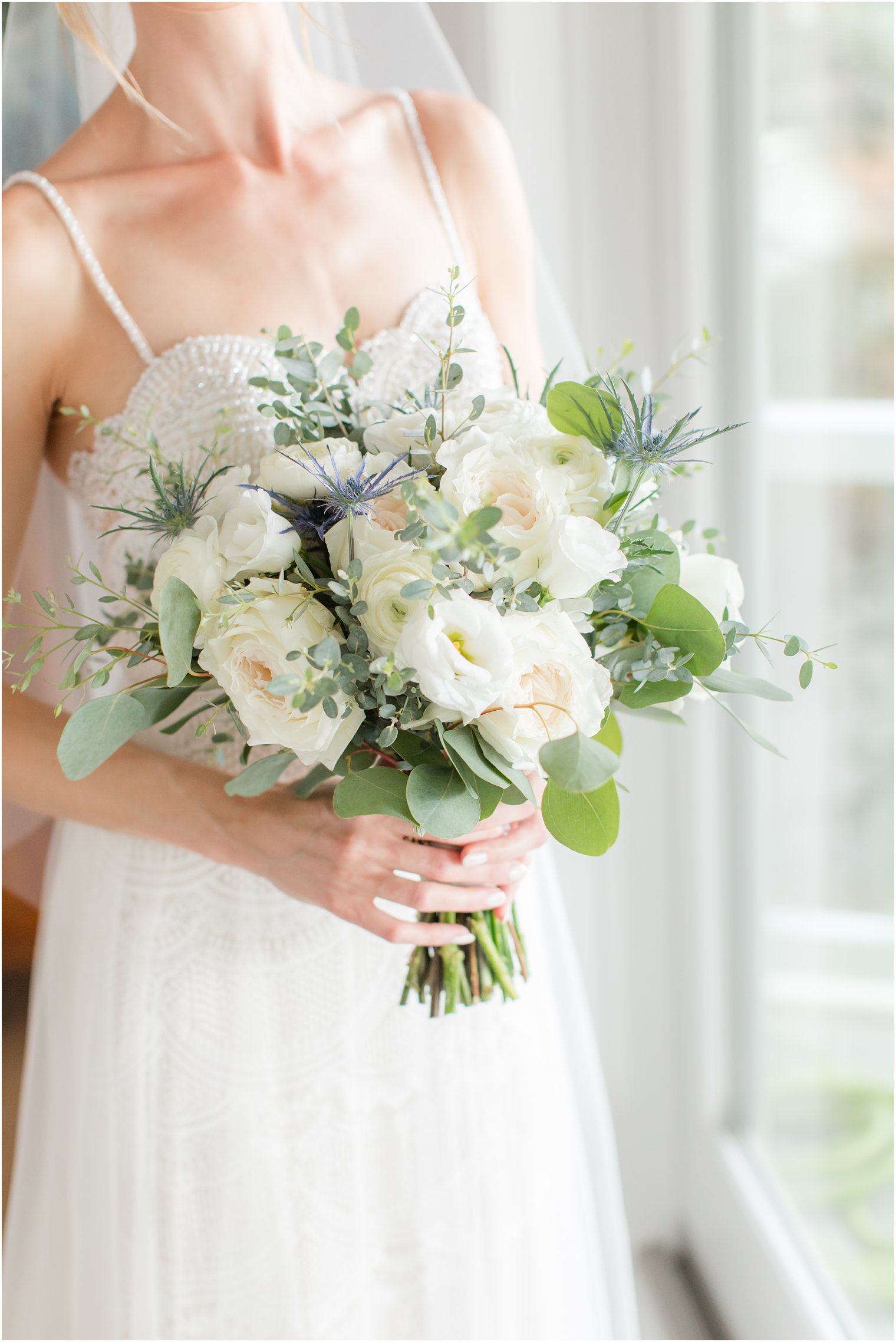 bride holds bouquet of white flowers and succulents 
