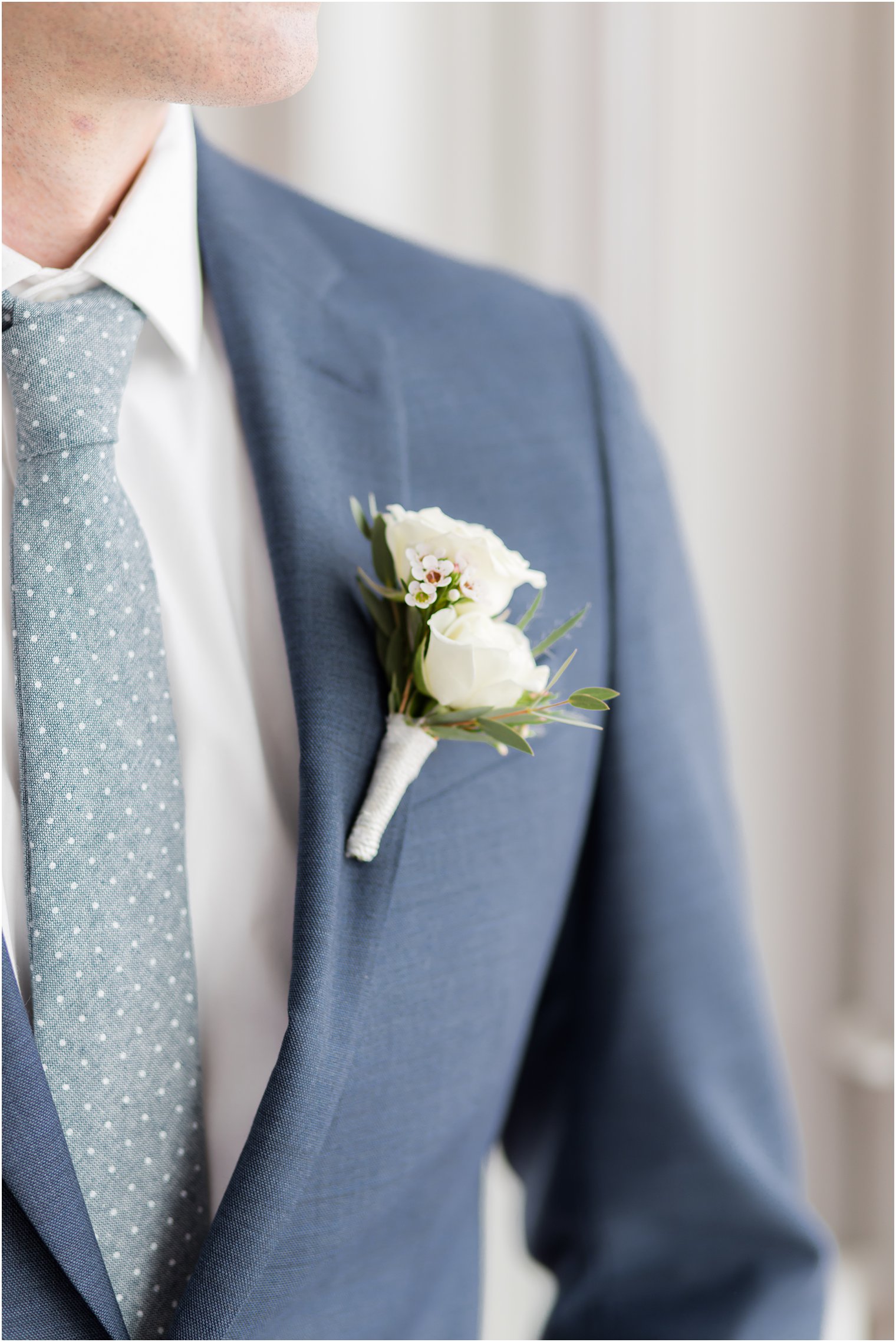 groom in navy suit with white boutonnière 