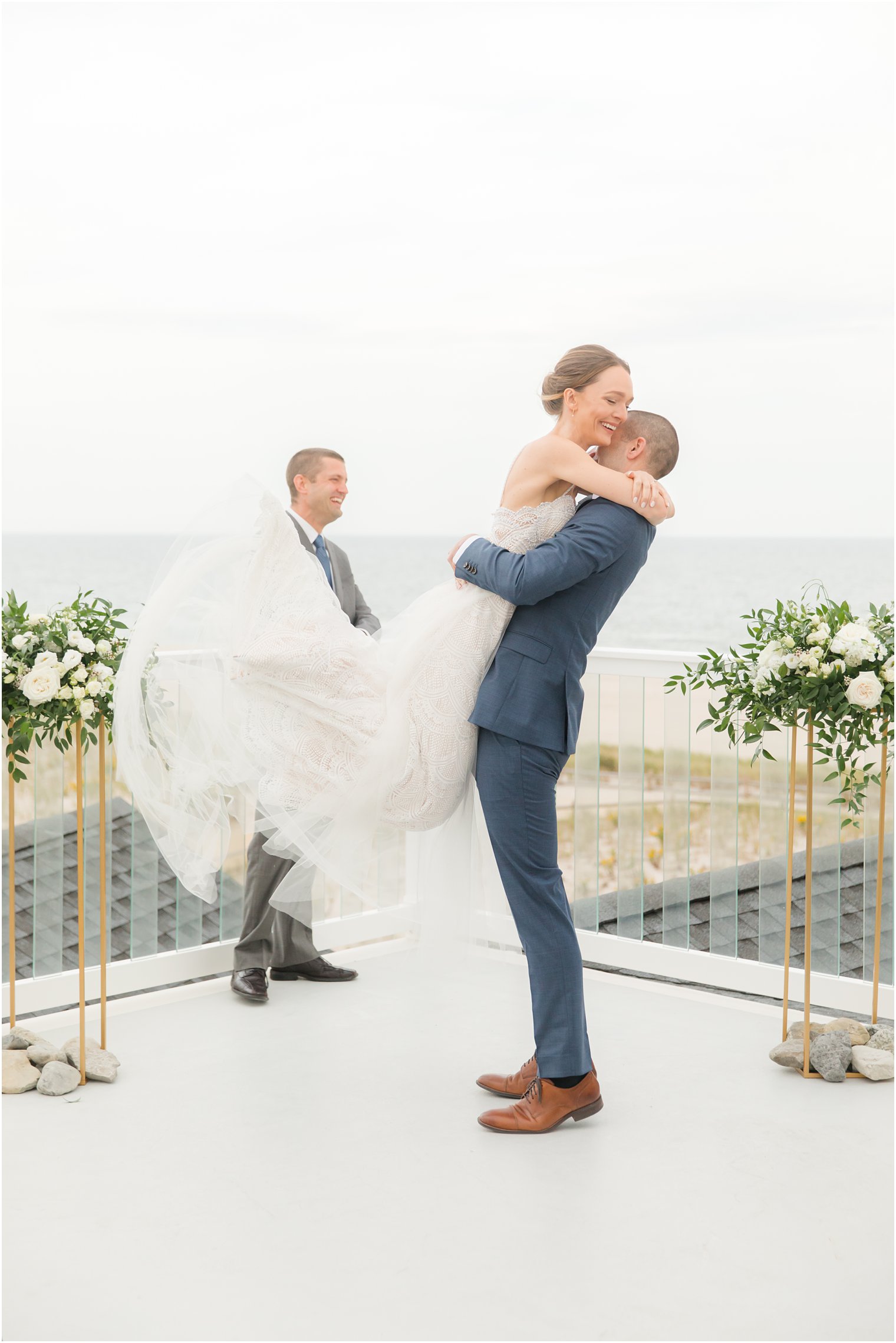 groom lifts bride after wedding ceremony on LBI rooftop