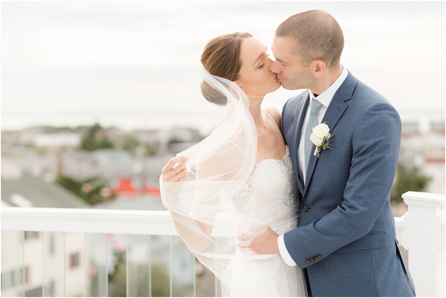 bride and groom kiss on rooftop on Long Beach Island
